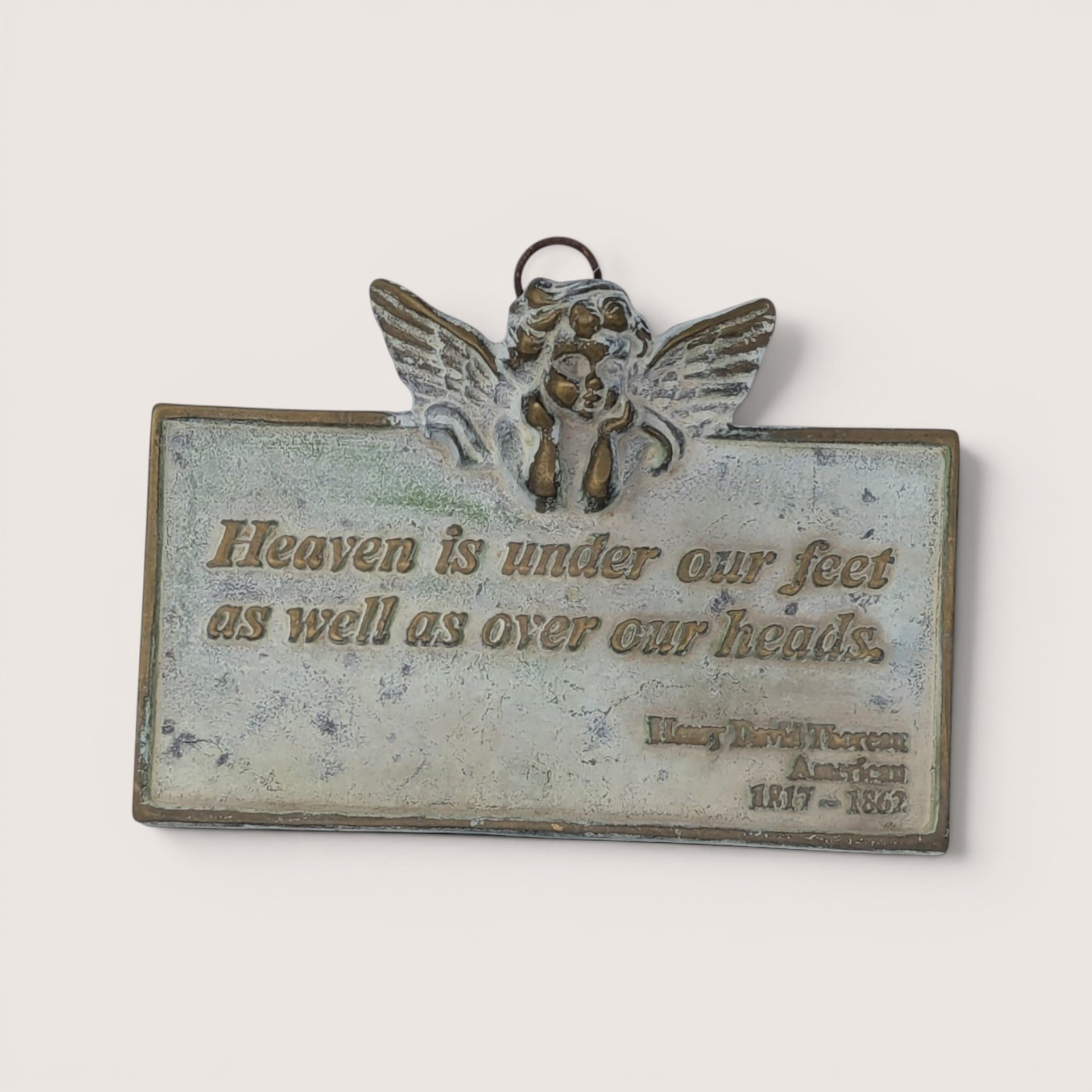 Vintage cast metal wall plaque with cherub detail featuring a Henry David Thoreau quote.