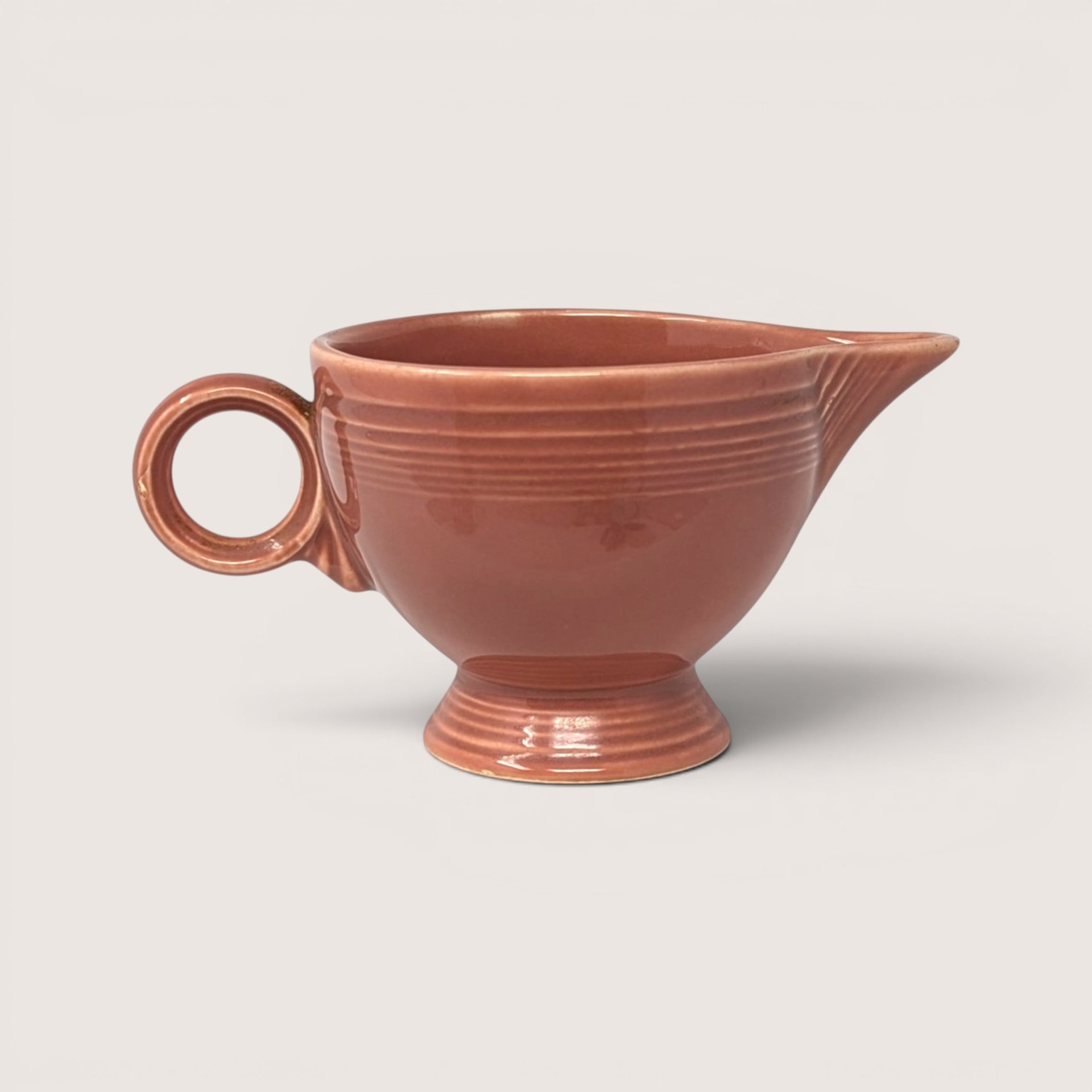 Vintage Fiesta rose ceramic gravy boat with handle and pouring spout.
