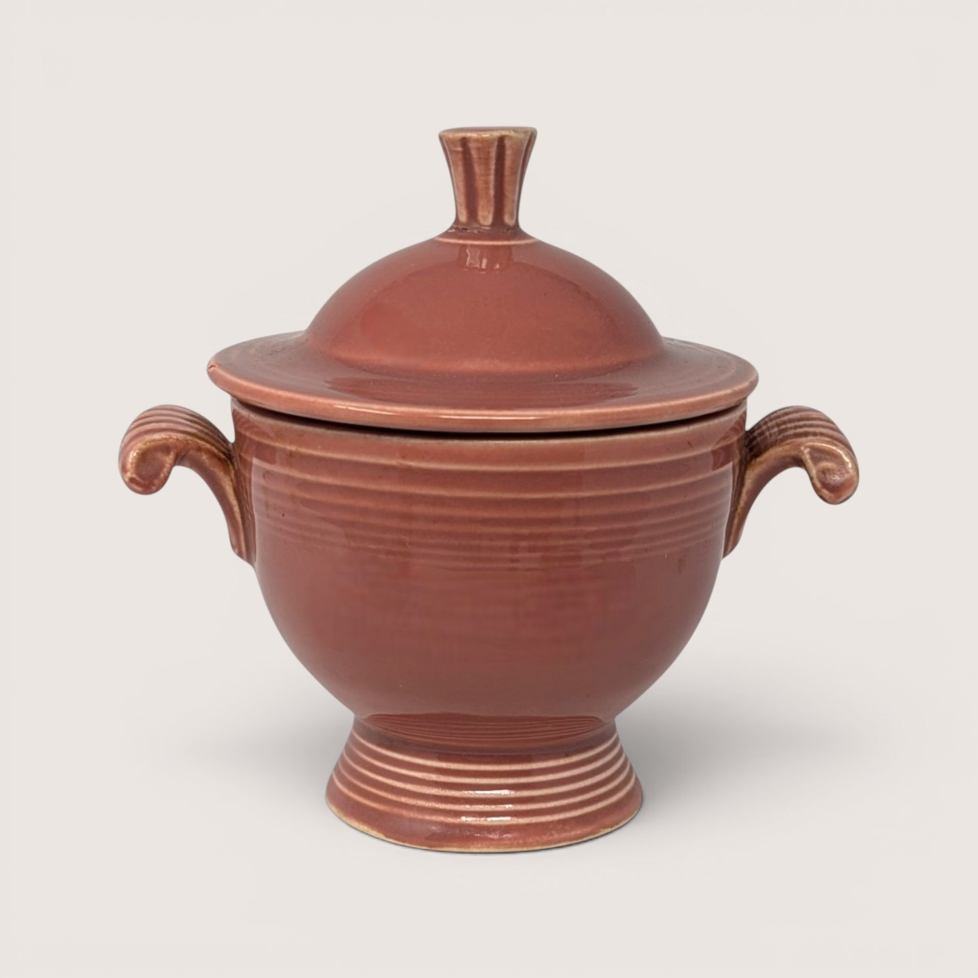 Vintage Fiesta rose ceramic sugar bowl with matching lid and dual handles.