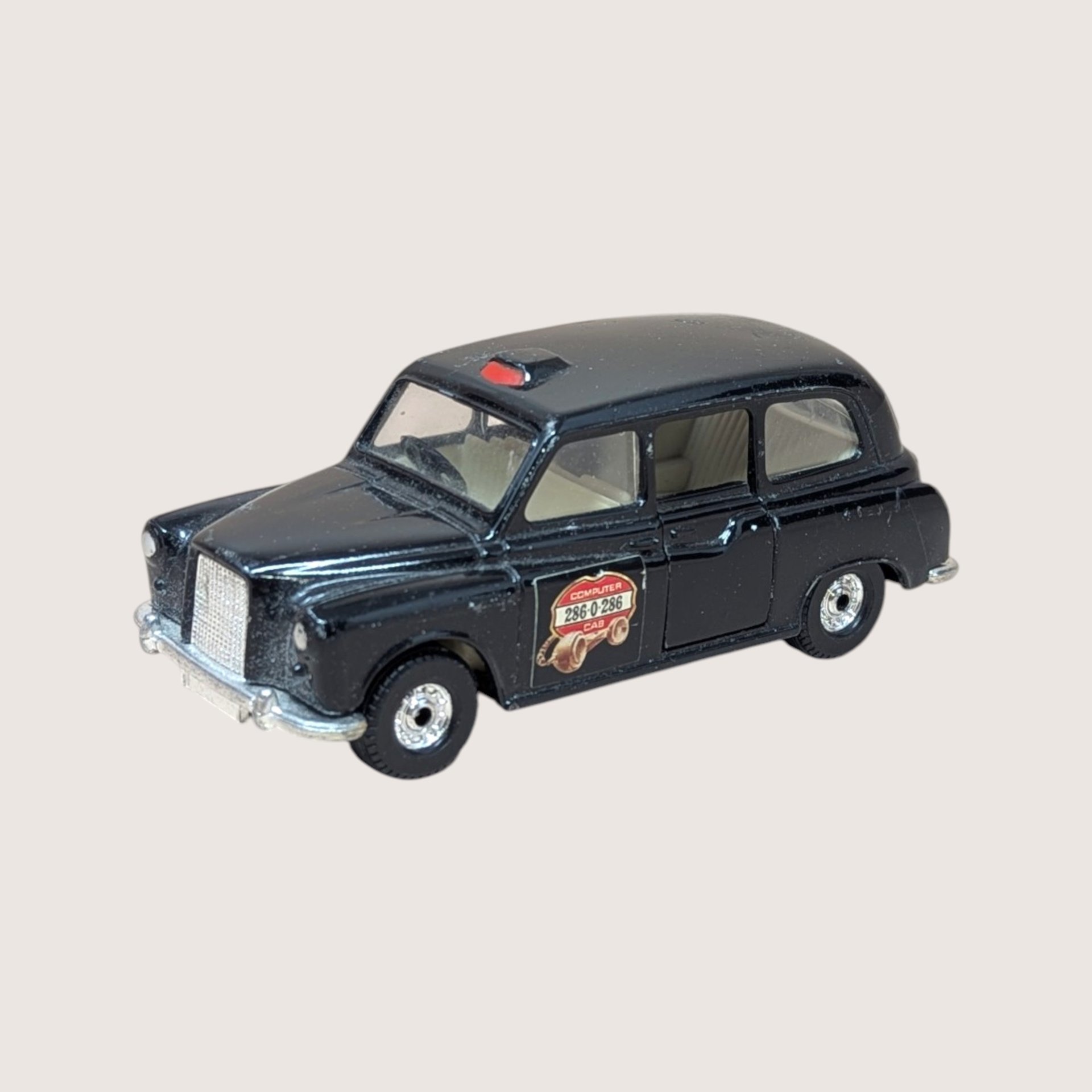 Vintage Corgi diecast black London taxi model with Computer Cab branding on the side.