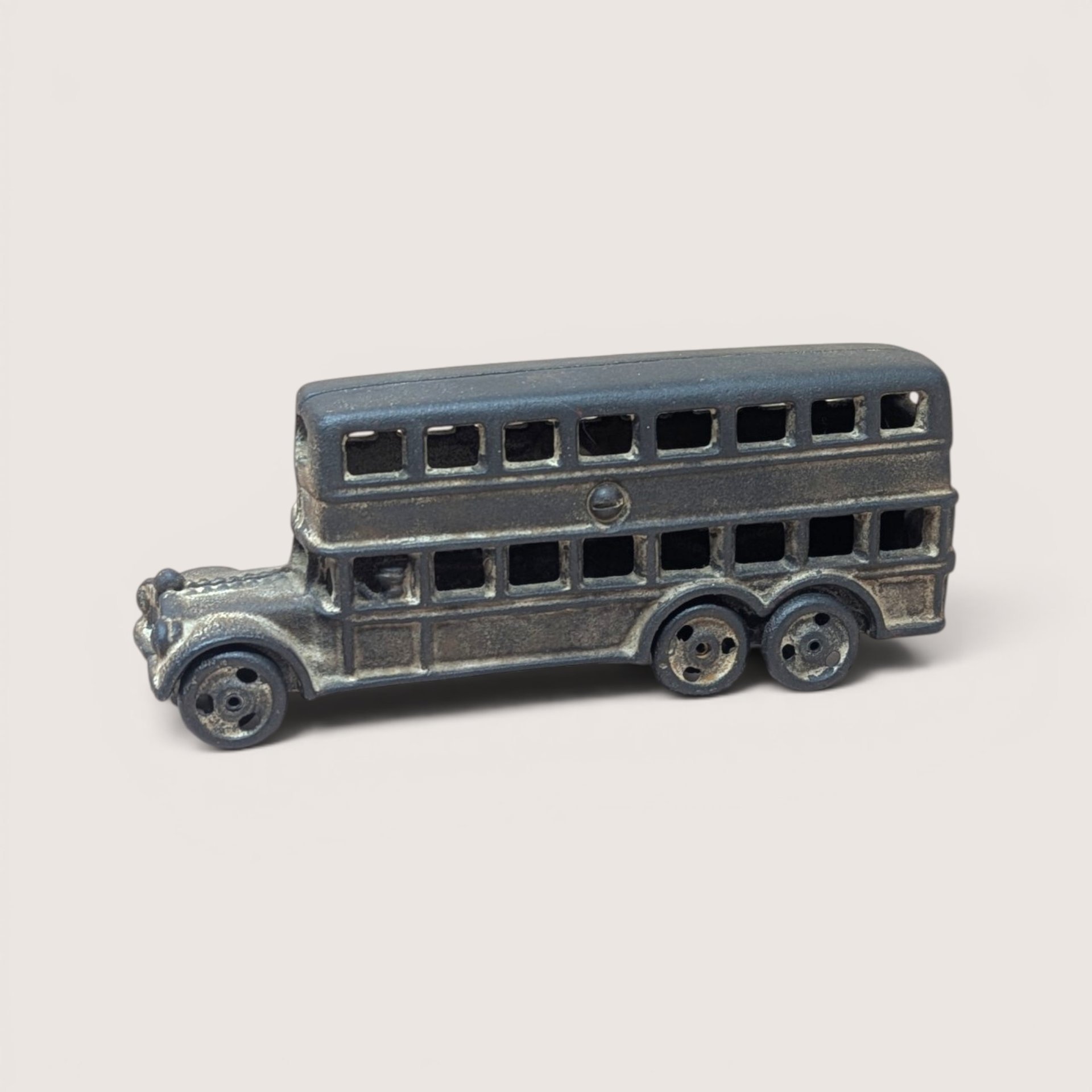 Antique style cast iron double decker bus toy in dark metal finish.