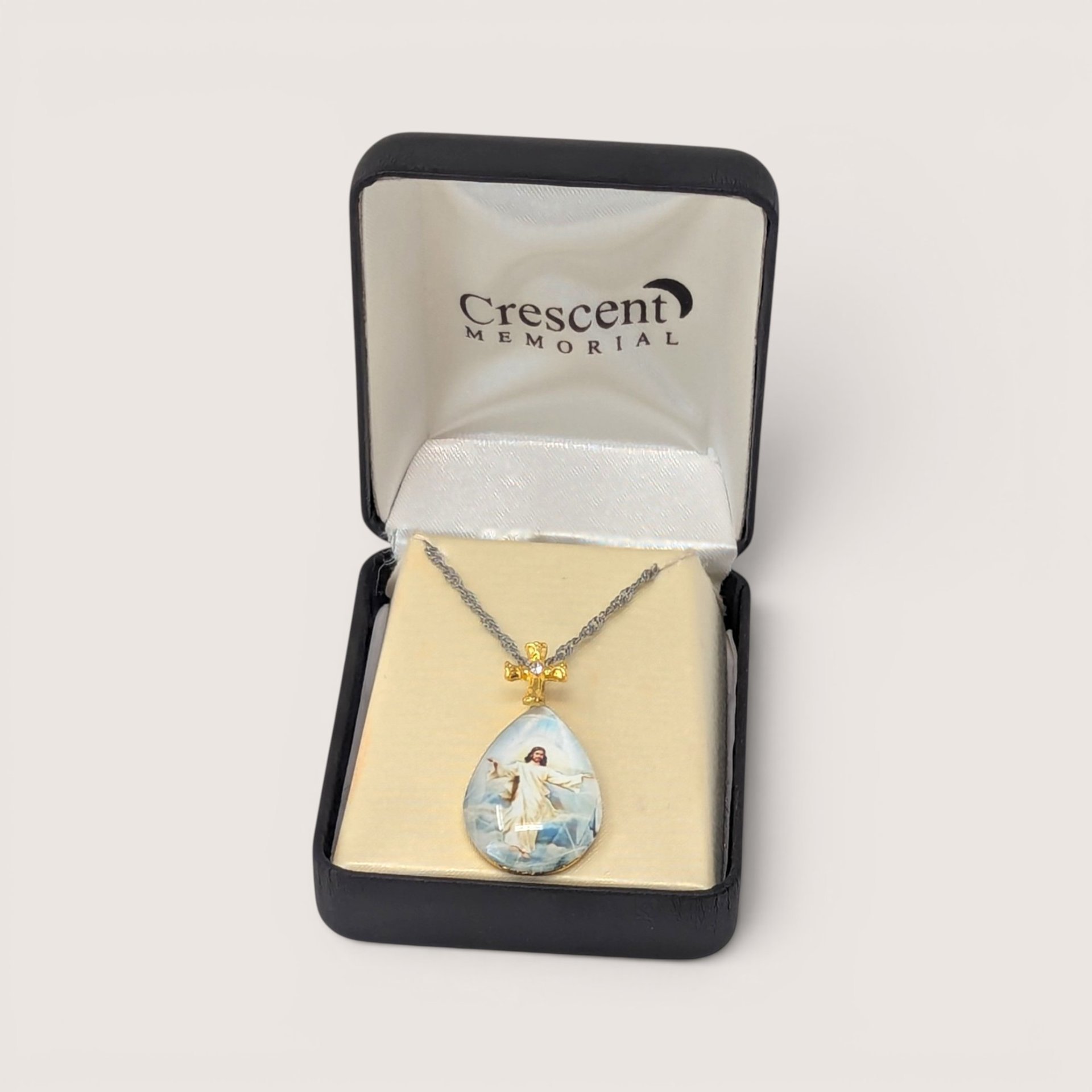 Vintage Crescent Memorial teardrop intaglio pendant with a cross bail, displayed in its original box with a chain.