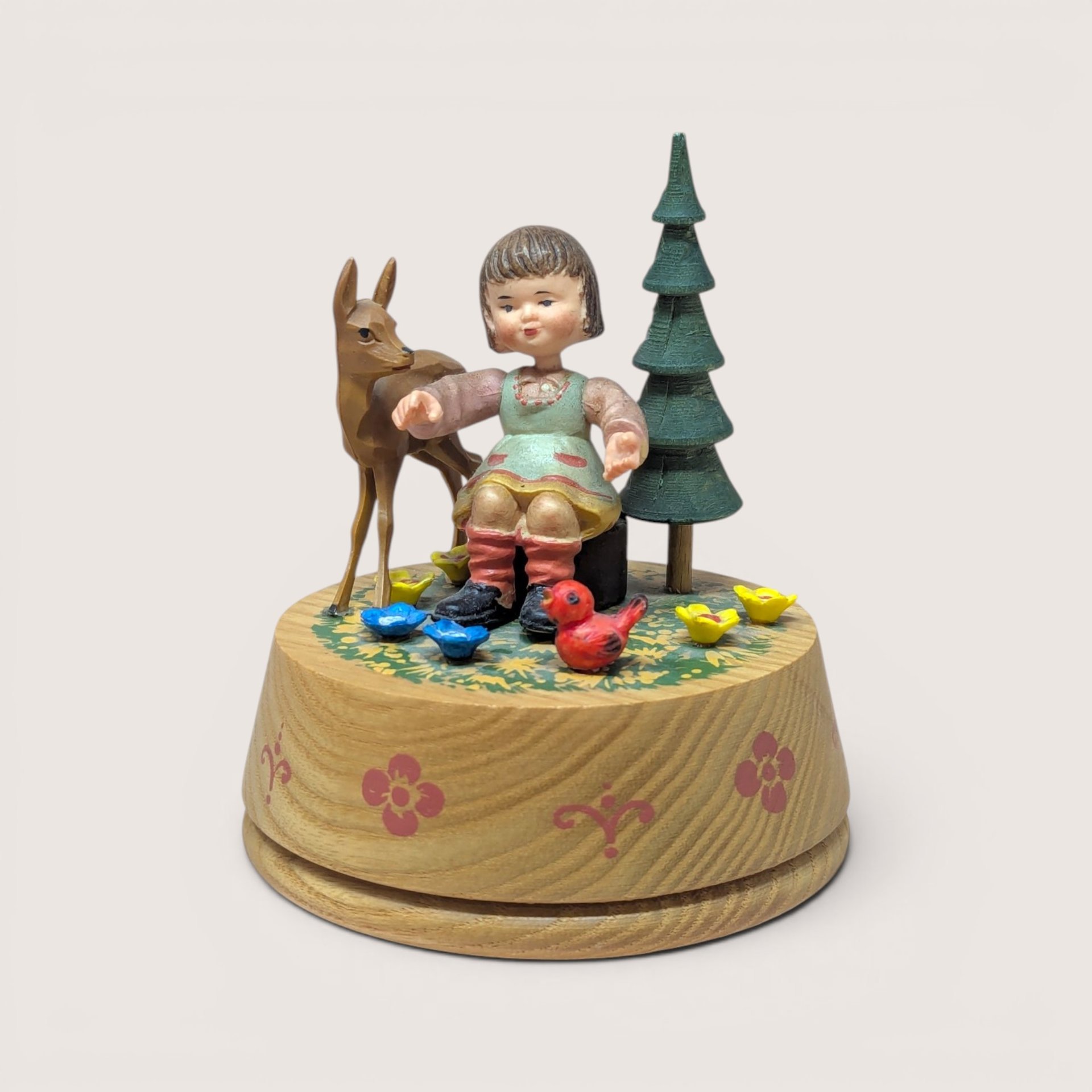 Vintage Anri wood-carved rotating music box featuring a girl, deer, and bird with hand-painted alpine details.