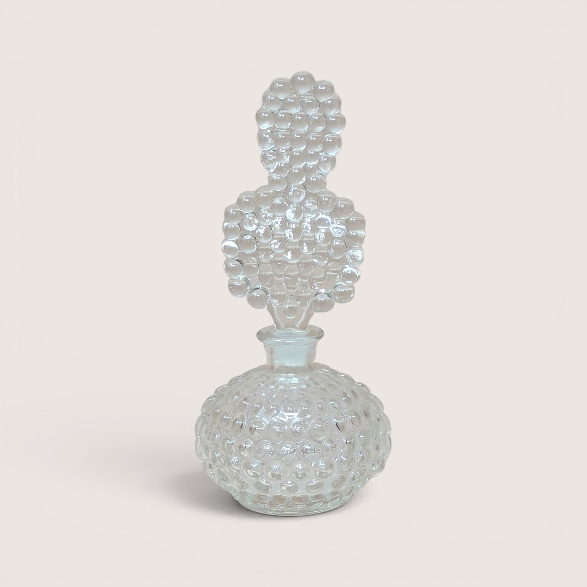 Vintage clear glass perfume bottle with a textured bubble pattern and unique bubble-shaped stopper.