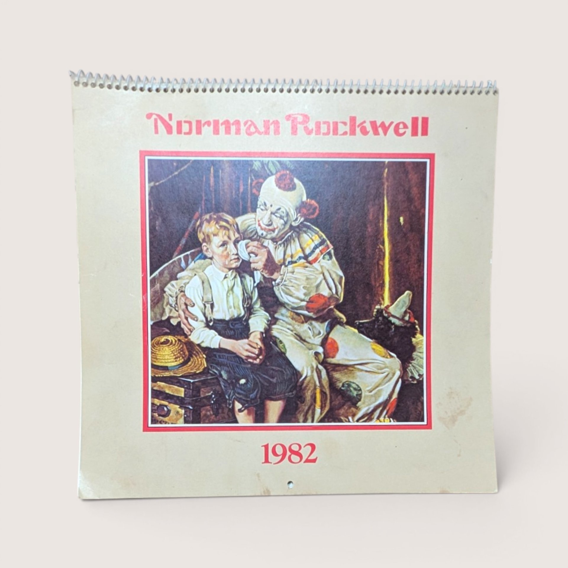 1982 Norman Rockwell calendar cover featuring a clown tending to a young boy.