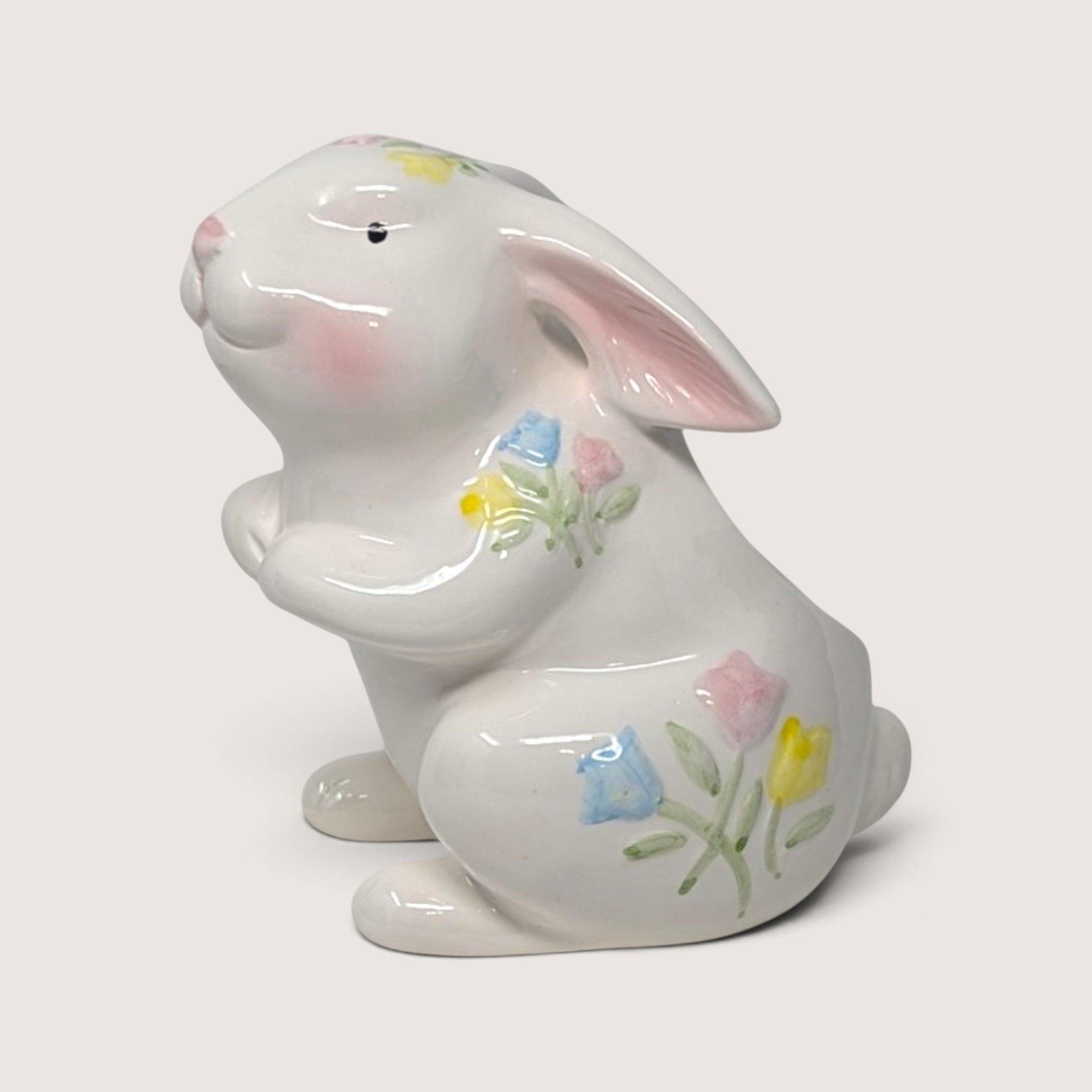 Vintage white ceramic bunny rabbit planter decorated with delicate pastel floral sprigs of pink, blue, and yellow flowers.