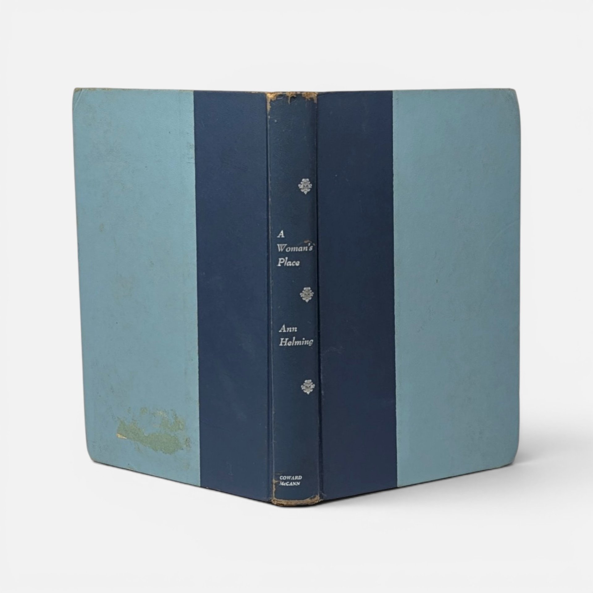Vintage 1962 hardcover book A Woman's Place by Ann Helming in blue cloth on a plain background.