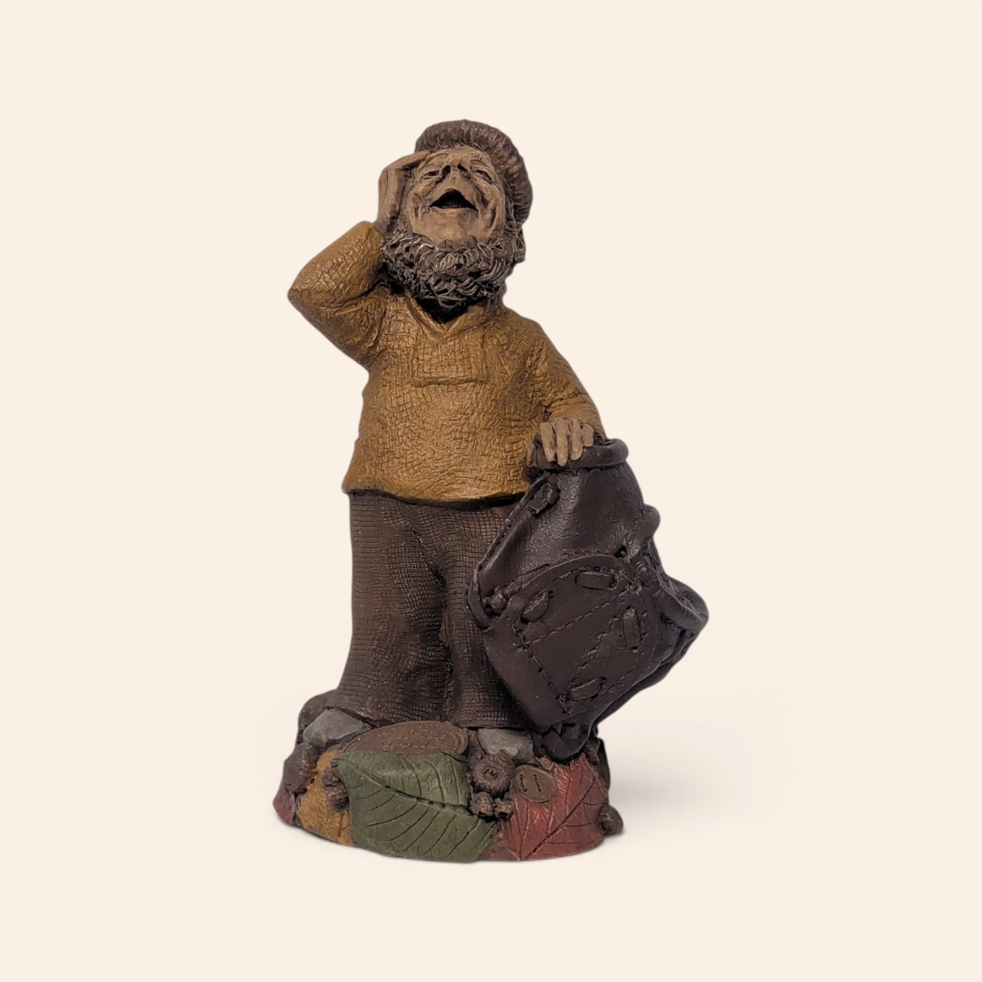 Vintage signed Tom Clark "Who" figurine depicting a bearded woodland gnome shielding his eyes atop a base of autumn leaves.
