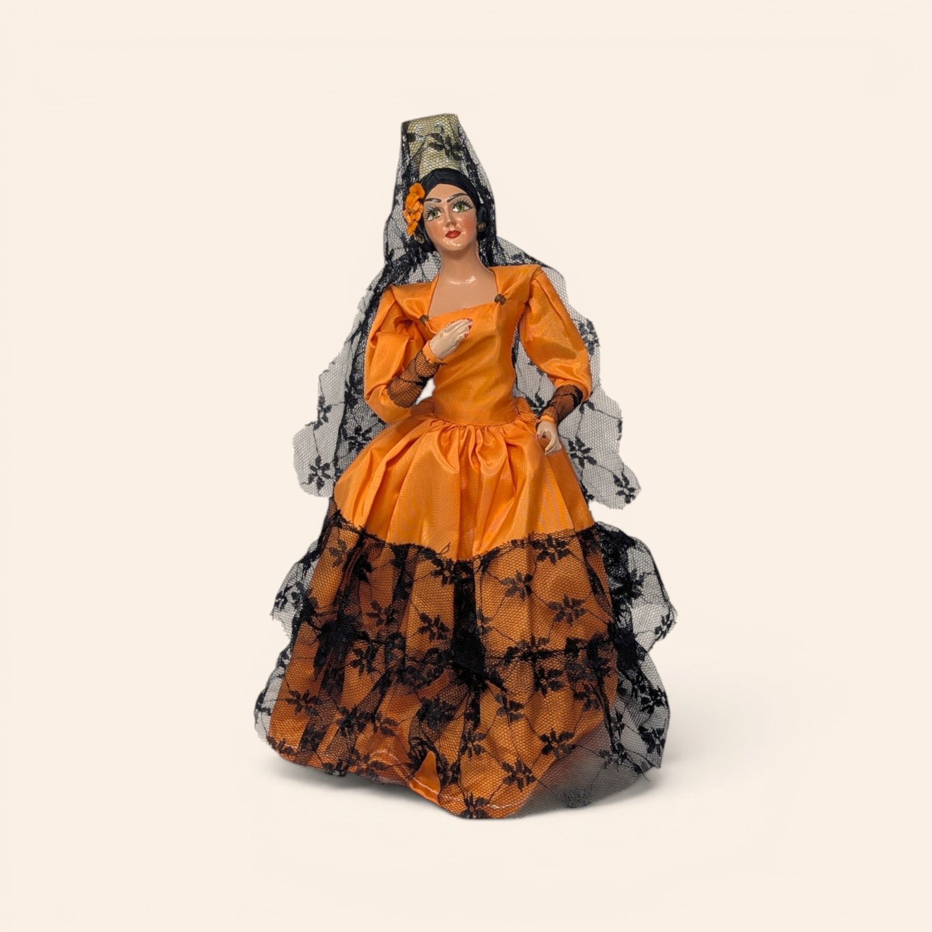 Vintage Spanish senorita doll wearing an orange dress with black lace trim and a matching veil.
