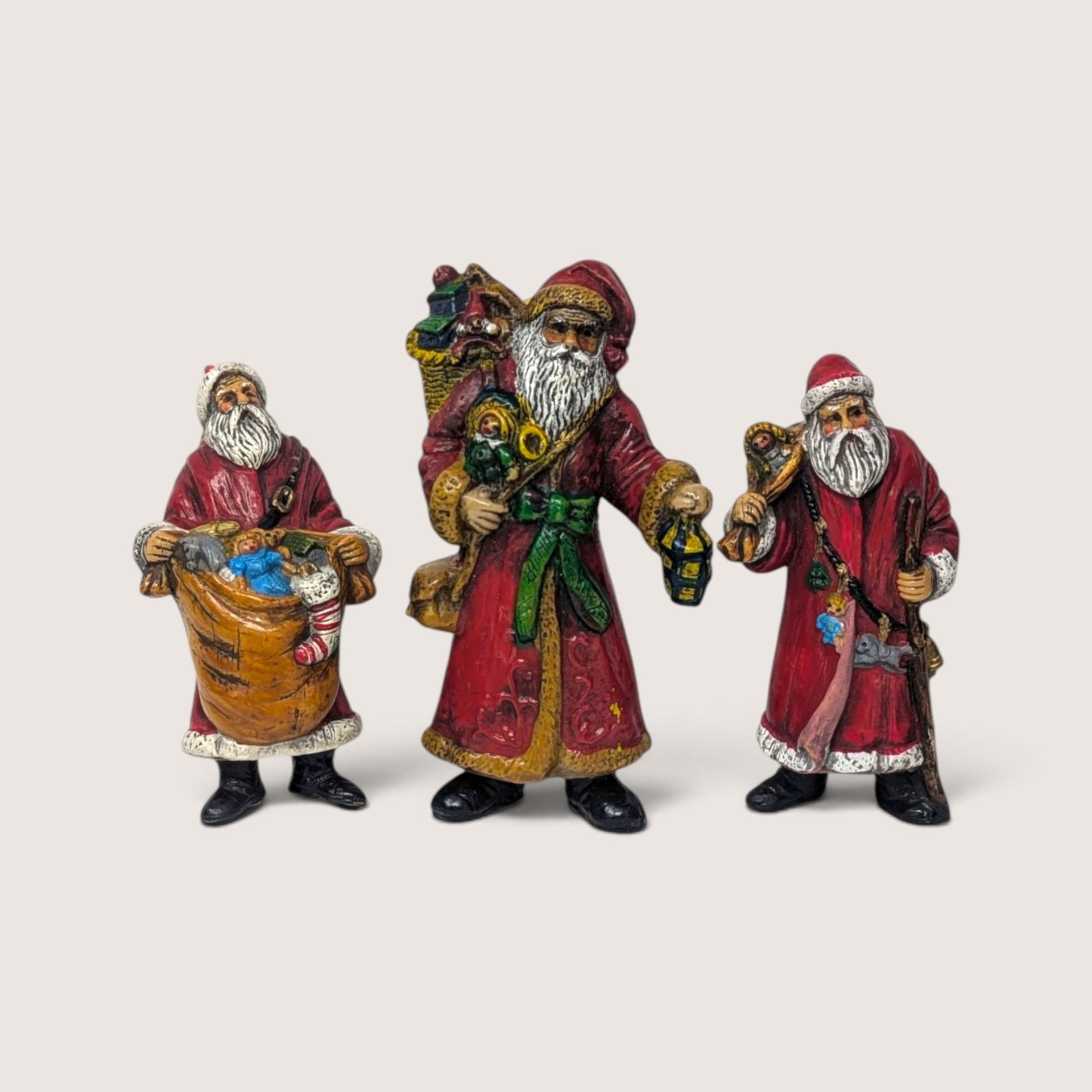 Set of 3 vintage plastic Santa Claus figures and ornaments in traditional red coats.