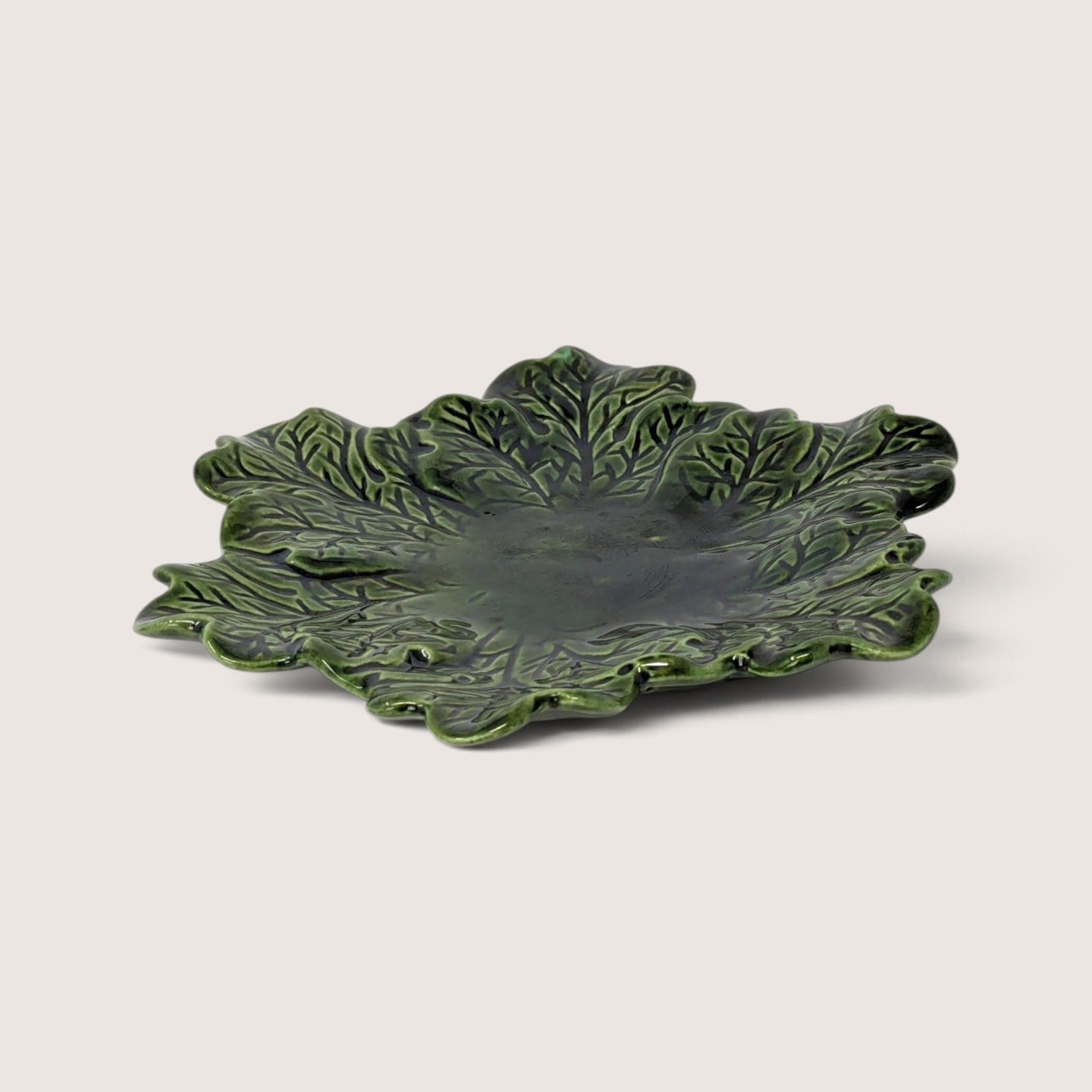 Vintage hand-painted green ceramic leaf plate featuring glossy majolica-style texturing and deep vein details.