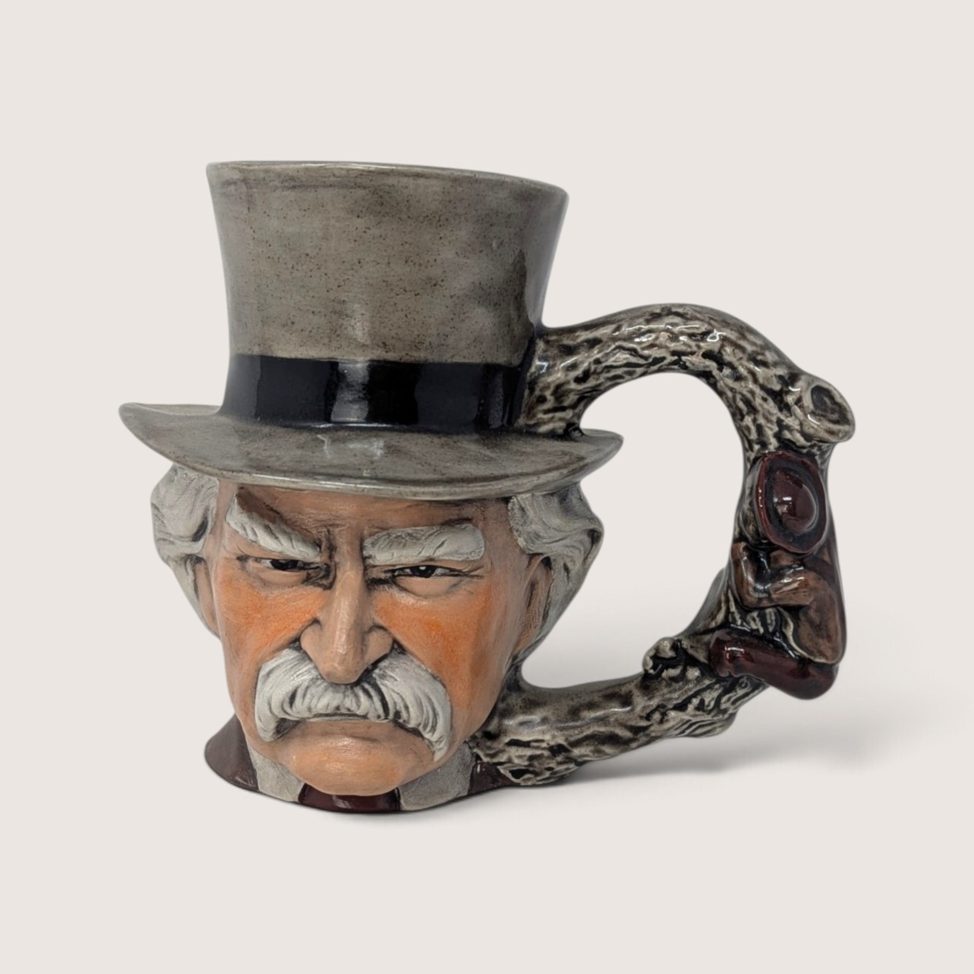 Vintage hand-painted ceramic character mug depicting Mark Twain in a top hat with a sculpted branch handle.
