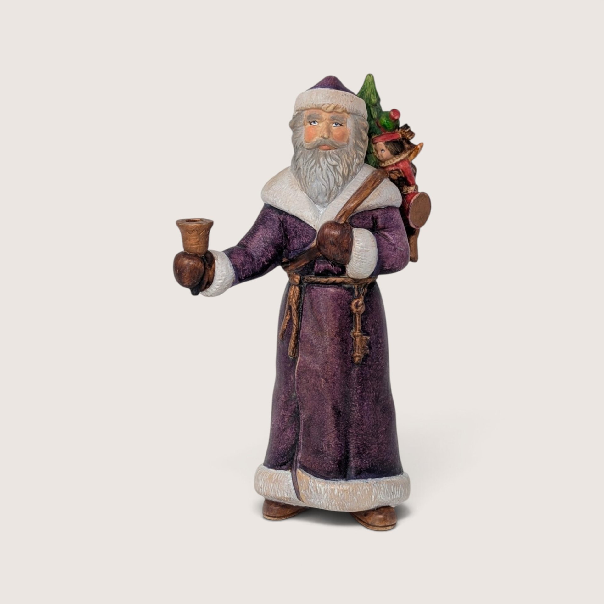 Vintage hand-painted ceramic old world Santa figurine wearing a purple robe and holding a bell.