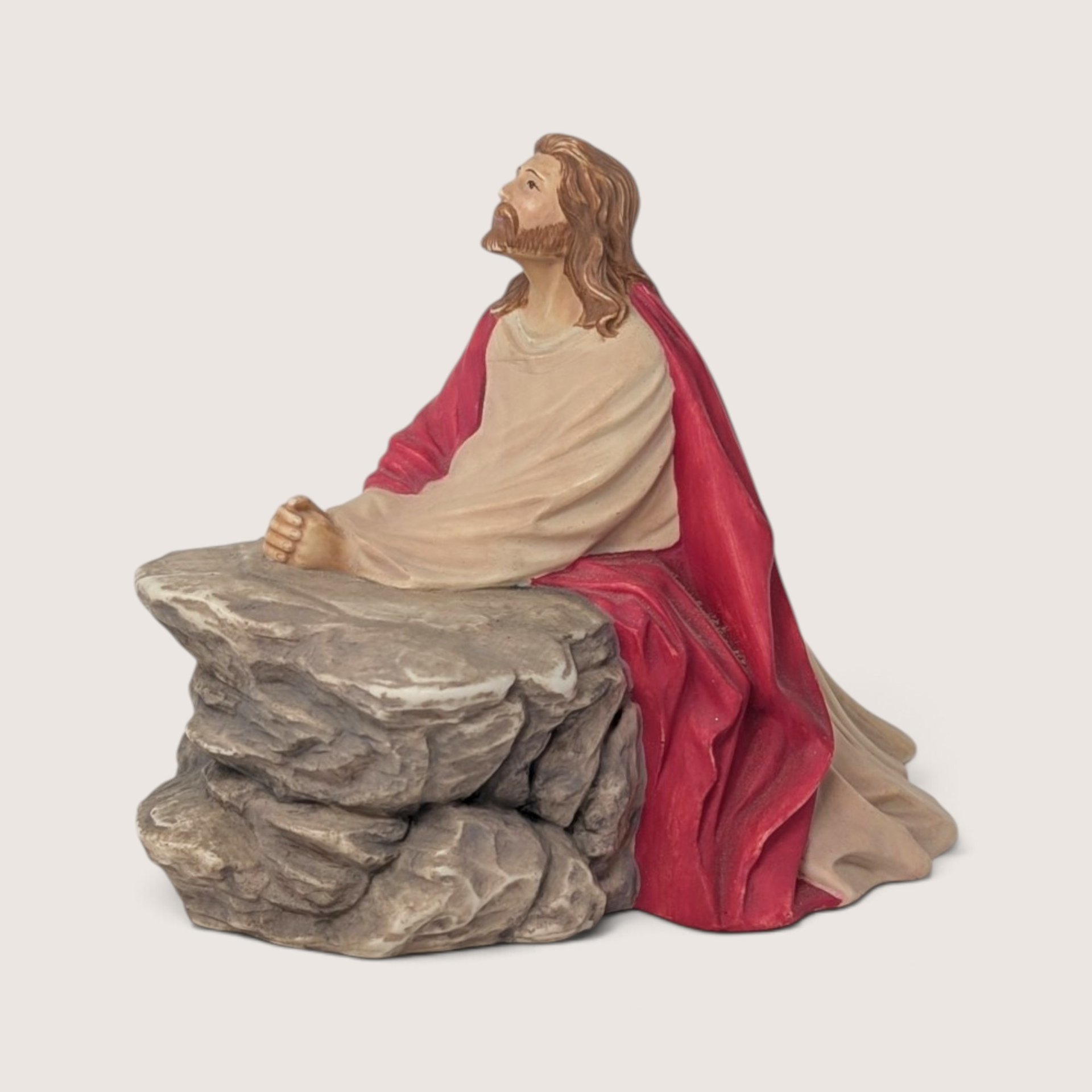 Vintage 1987 Byron mold hand-painted ceramic figurine of Jesus praying at a rock ledge in red and cream robes.