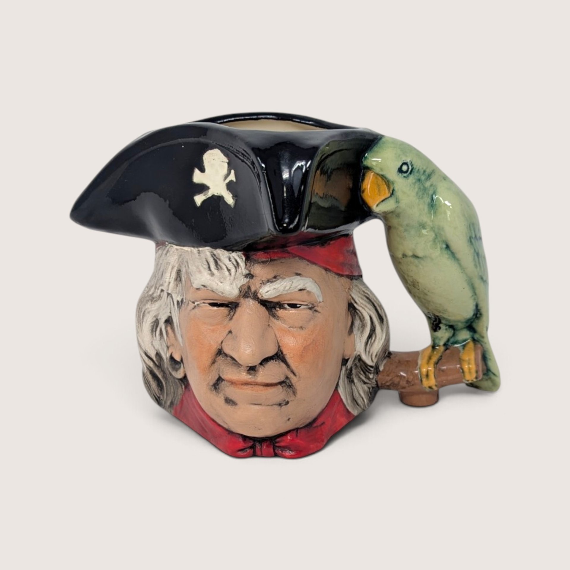 Vintage hand-painted ceramic character mug depicting Long John Silver with a parrot handle and skull tricorn hat.