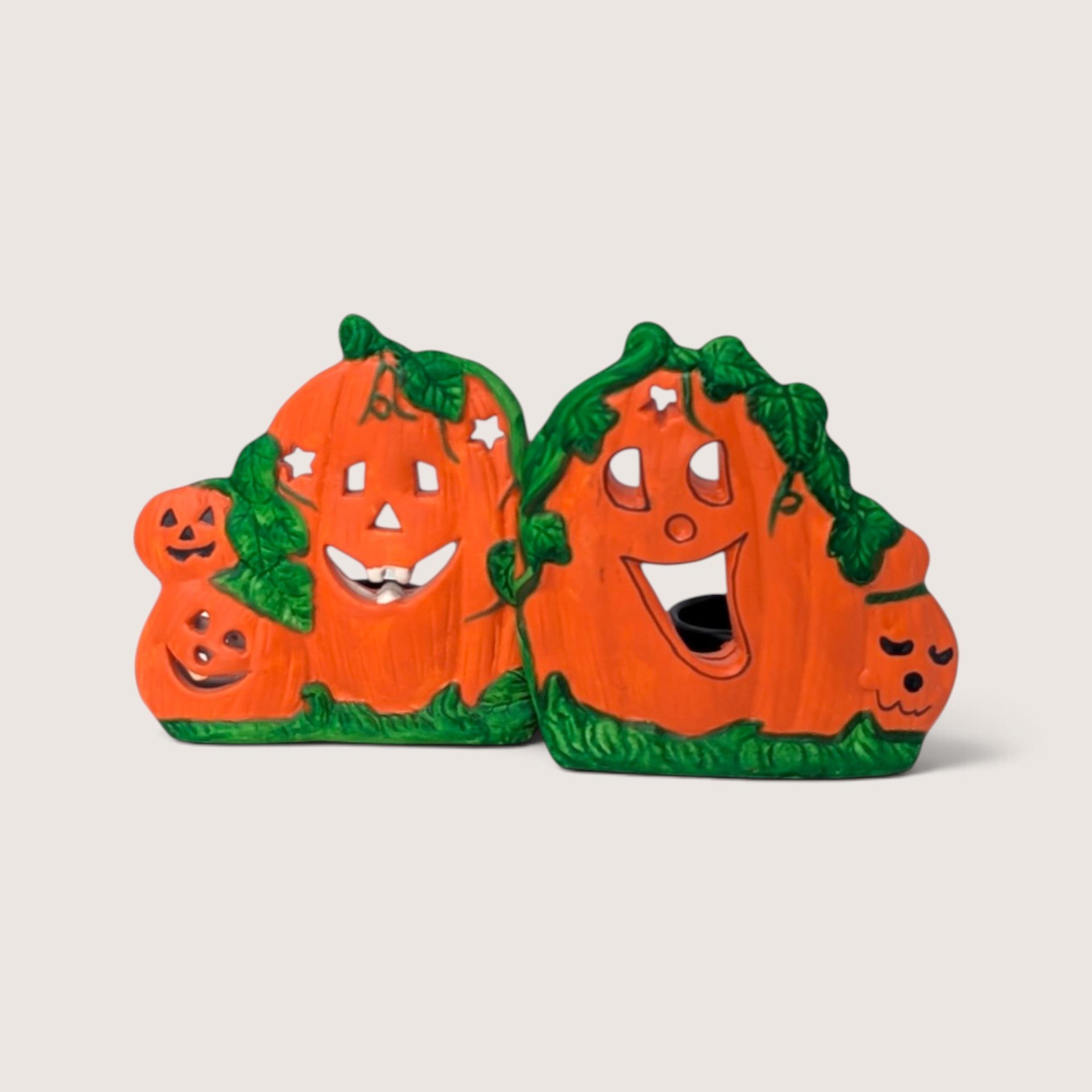 Vintage K's Collection ceramic Halloween jack-o'-lantern candle holder pair with carved pumpkin faces.