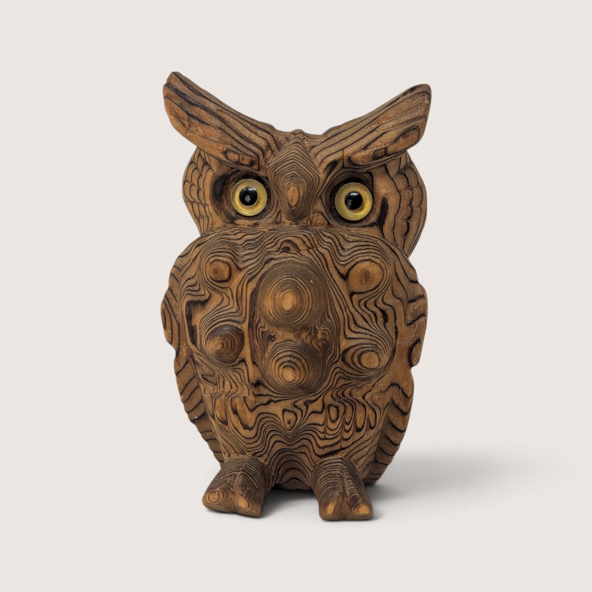 Vintage exotic wood carved owl figurine with natural grain patterns and inset yellow glass eyes.