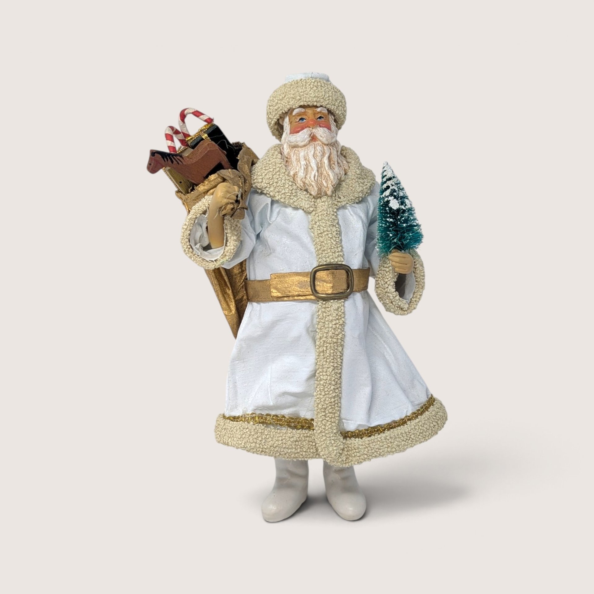 Vintage 1988 Clothique Possible Dreams Santa figurine wearing a white coat with textured trim and a gold belt, carrying a bag of toys and a small tree.
