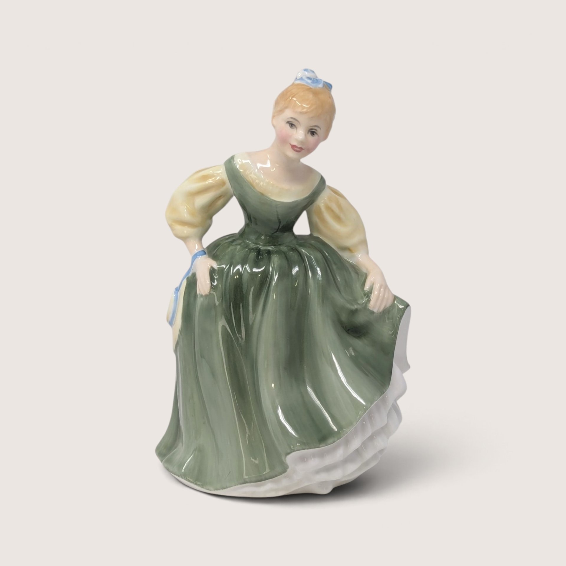 Vintage Royal Doulton Fair Maiden porcelain figurine depicting a woman in an olive green dress and blue hair bow.