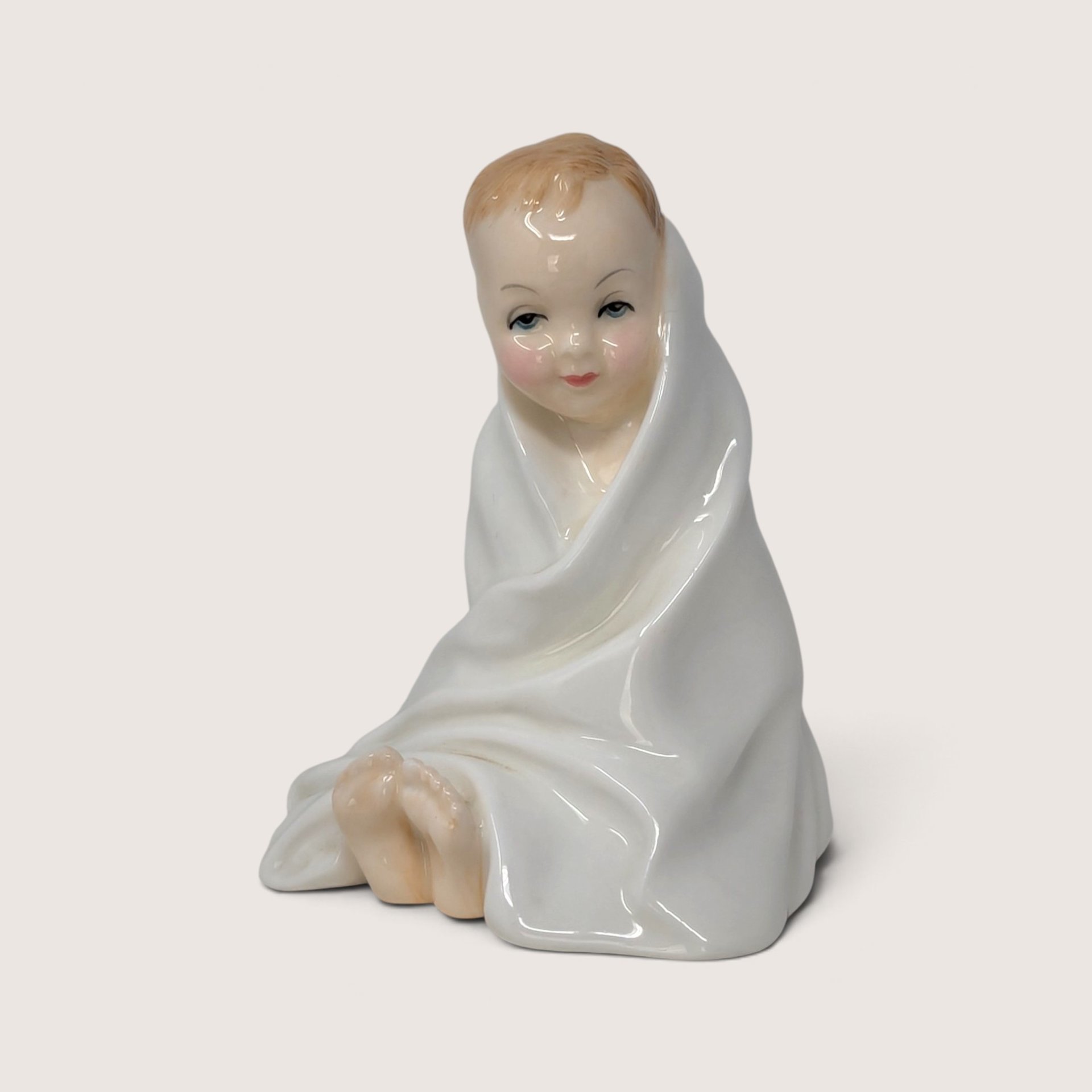 Vintage Royal Doulton porcelain figurine titled This Little Pig showing a toddler wrapped in a white blanket.