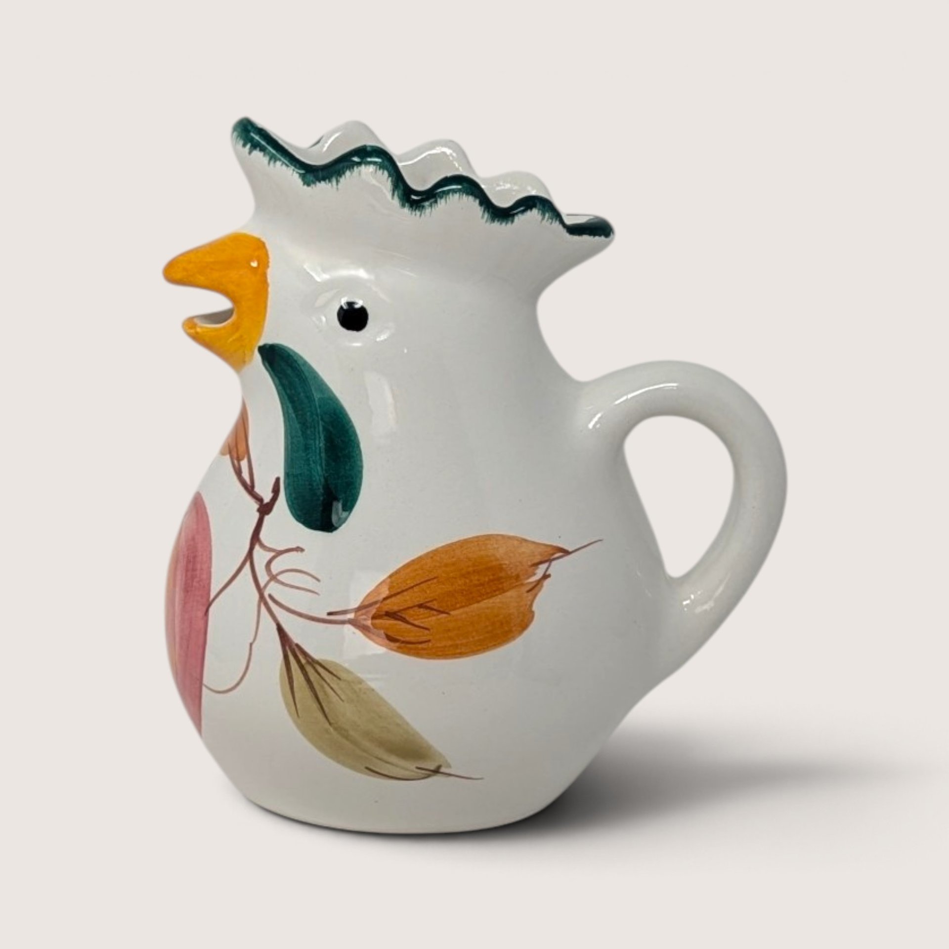 Vintage Italian ceramic chicken creamer featuring hand-painted botanical motifs and a green crest handle design.