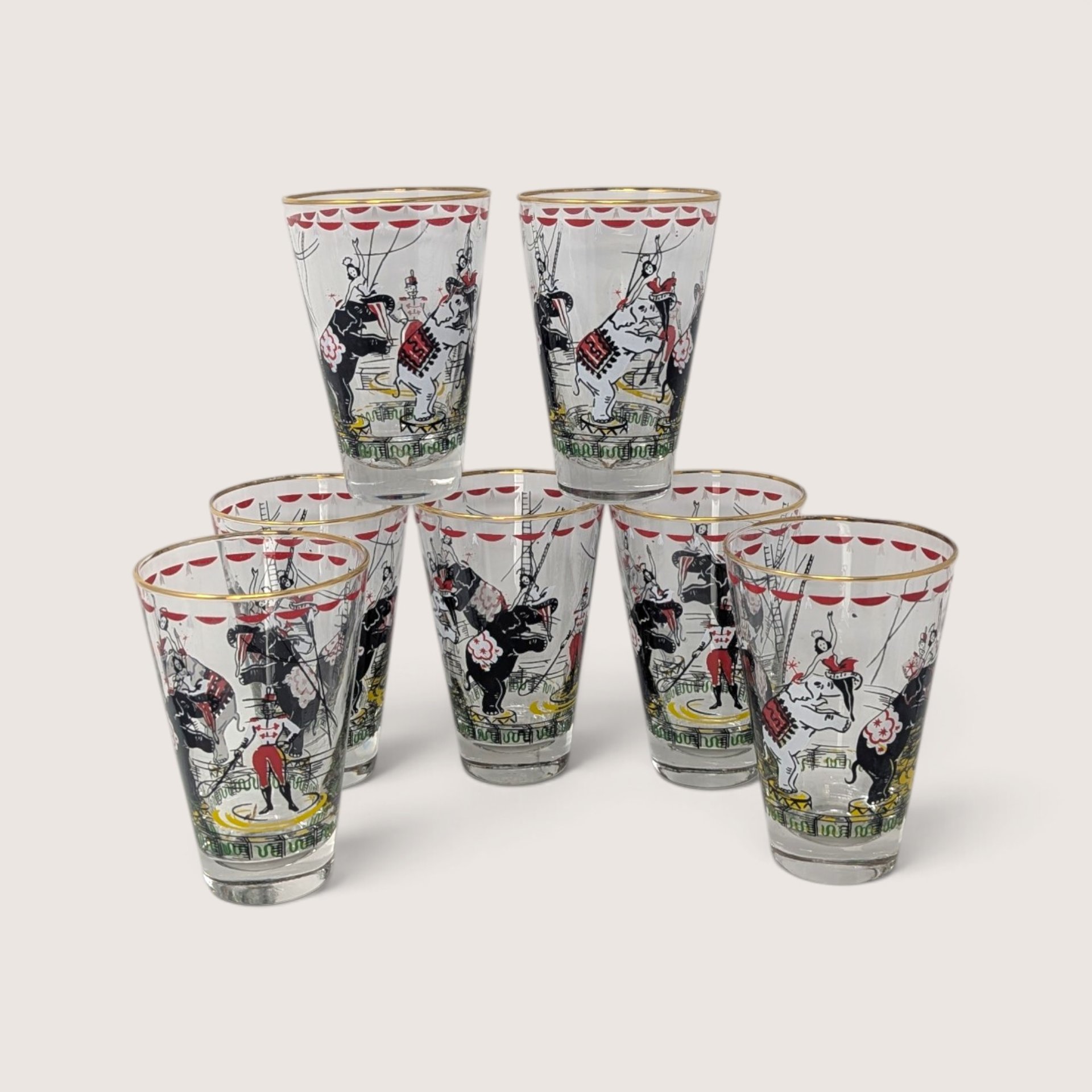 Vintage set of clear glass circus tumblers featuring performing elephants, circus acts, and gold rims.