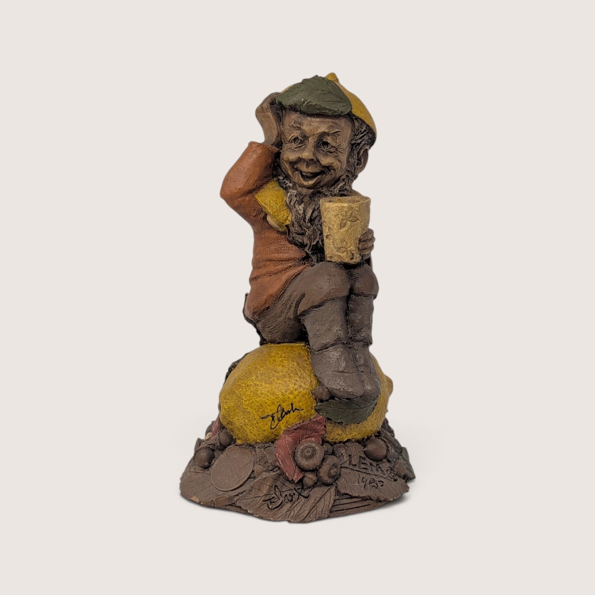 A vintage Tom Clark signed "Lem" resin gnome figurine from Cairn Studio, sitting on top of a textured lemon.