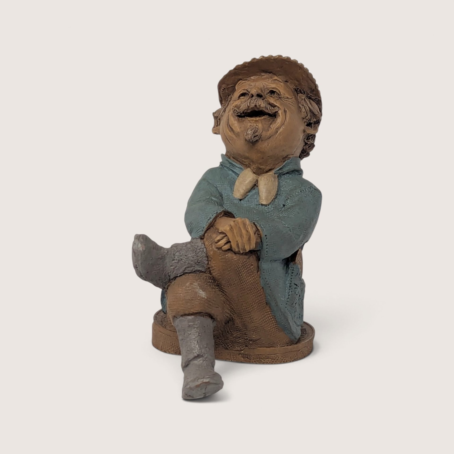 A vintage Tom Clark signed "Marty" resin gnome figurine from Cairn Studio, sitting with crossed legs and a laughing expression.