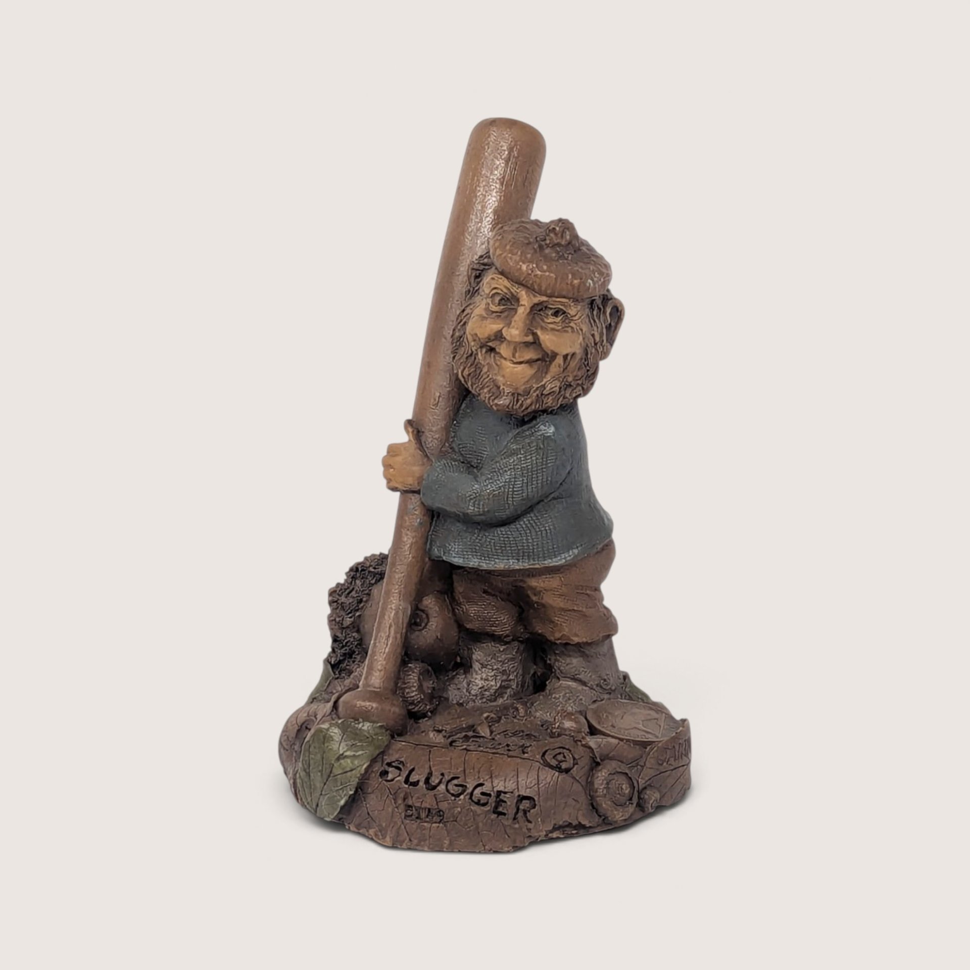 A vintage Tom Clark signed "Slugger" resin gnome figurine from Cairn Studio, standing next to a large baseball bat.