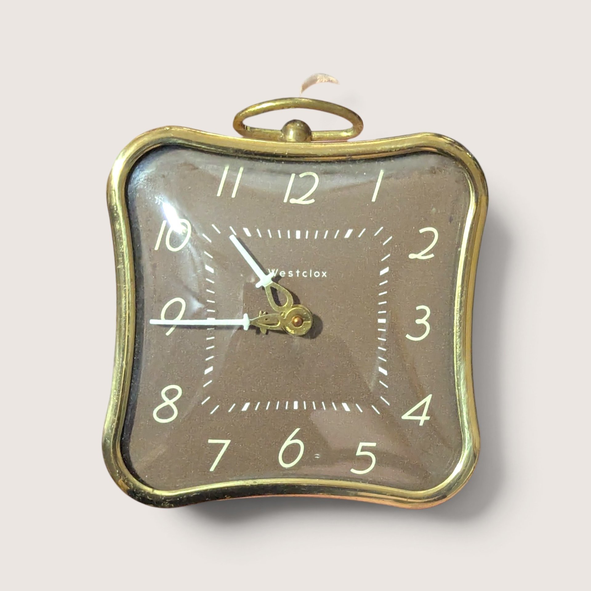 A vintage pink square Westclox La Sallitta alarm clock with gold trim, shown from the front dial and the pink metal back.