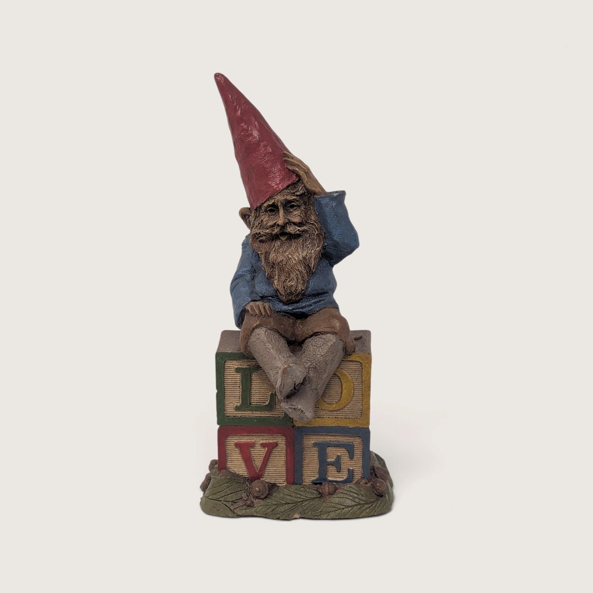 A vintage 1984 Tom Clark resin gnome figurine titled Spock sitting on stacking blocks that spell love against a neutral background.