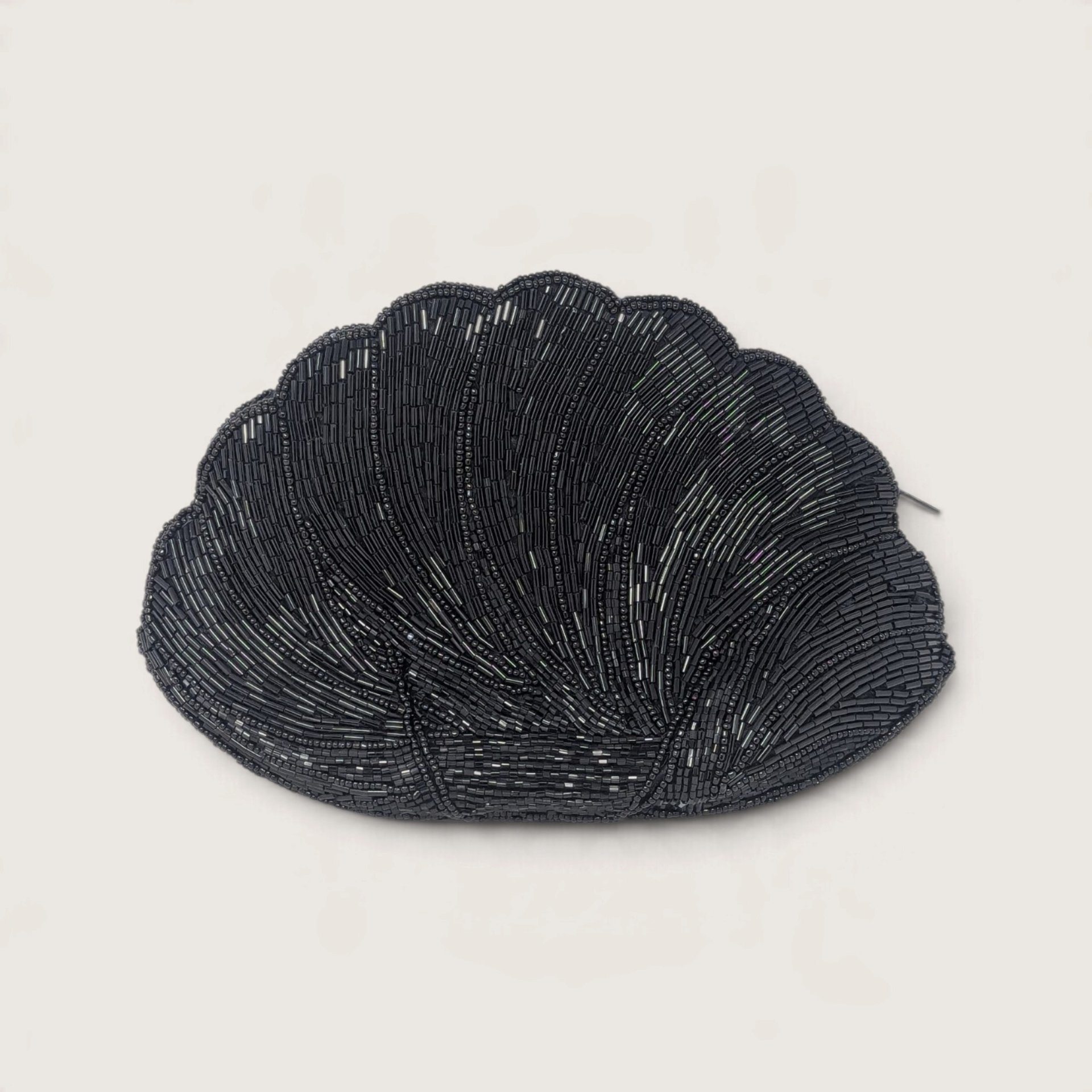 Vintage black glass bugle beaded clamshell-shaped evening clutch purse with zipper on a neutral background.   