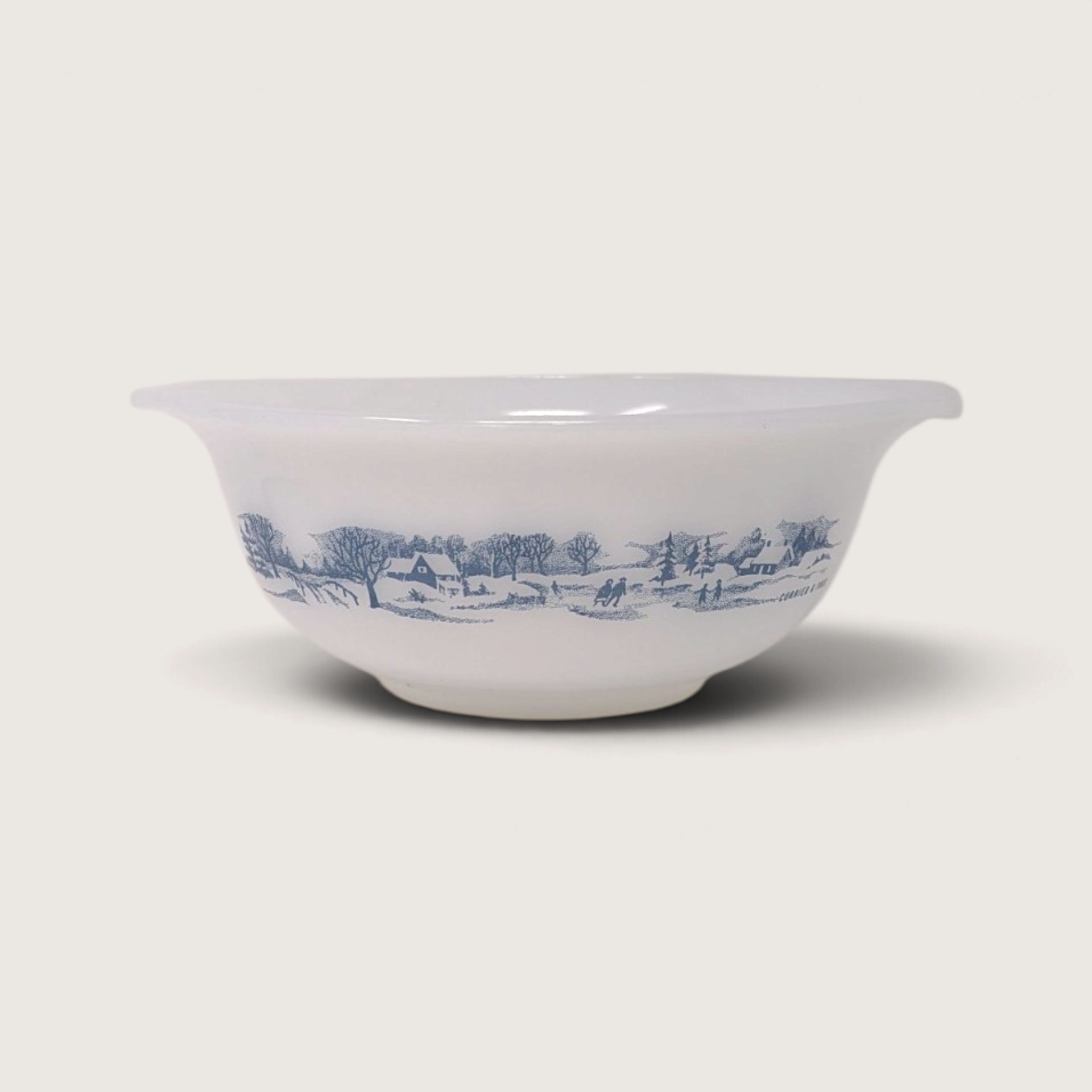 Vintage Glasbake white milk glass round casserole serving dish featuring a blue Currier and Ives winter landscape on white backdrop.   