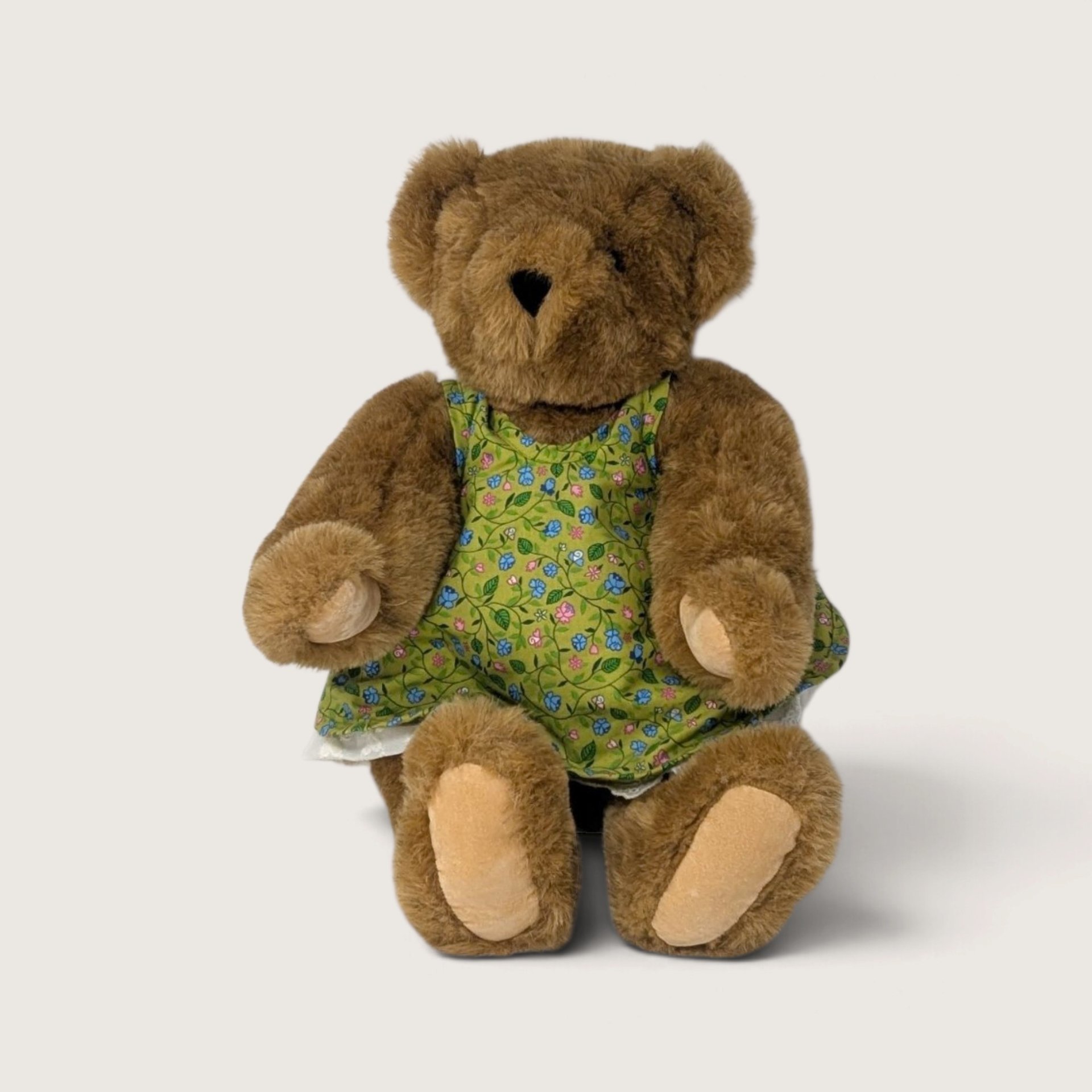 Vintage Vermont Teddy Bear brown jointed girl teddy bear sitting in a green floral dress with lace trim.   