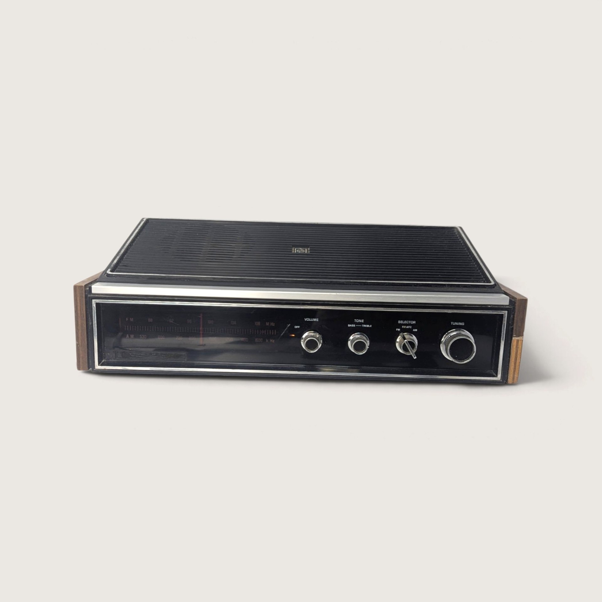 Vintage 1970s Panasonic RE-7441 AM/FM tabletop radio with black top speaker grille, faux woodgrain sides, and chrome dials.   
