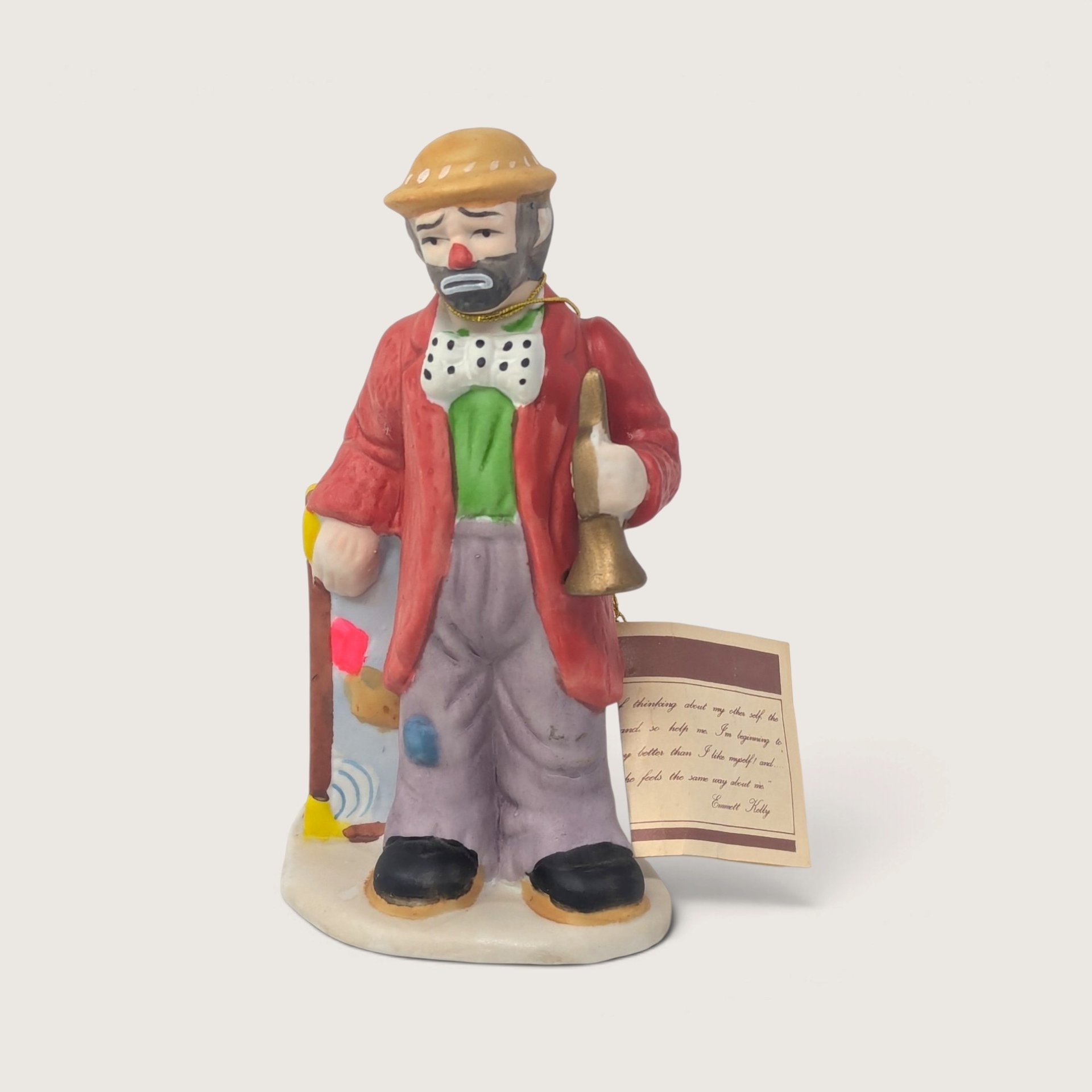 Vintage Flambro Emmett Kelly Jr Weary Willie porcelain clown figurine in a red coat holding a horn with hangtag.   