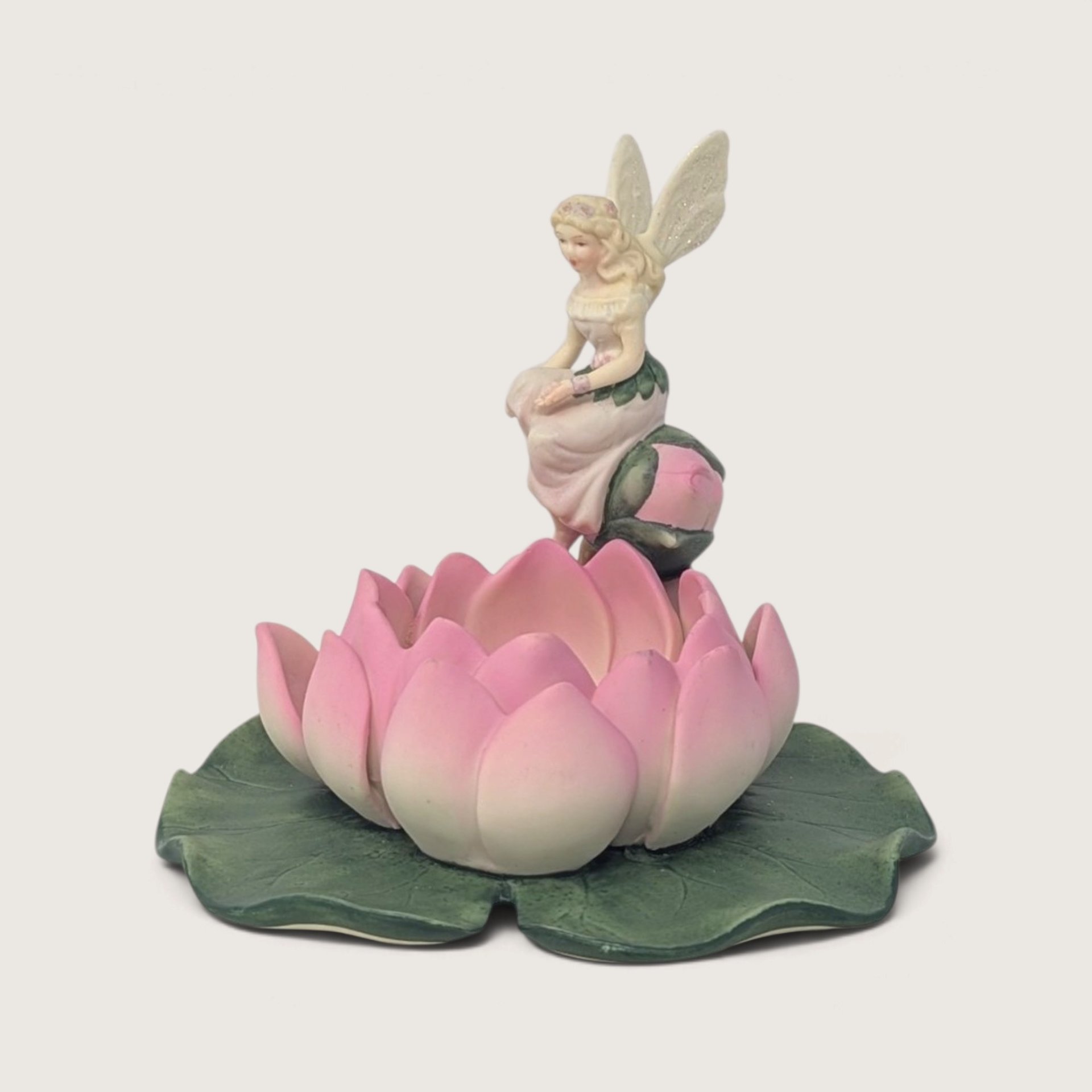 Vintage PartyLite ceramic candle holder featuring a blonde fairy perched on a pink water lily flower and green pad.   