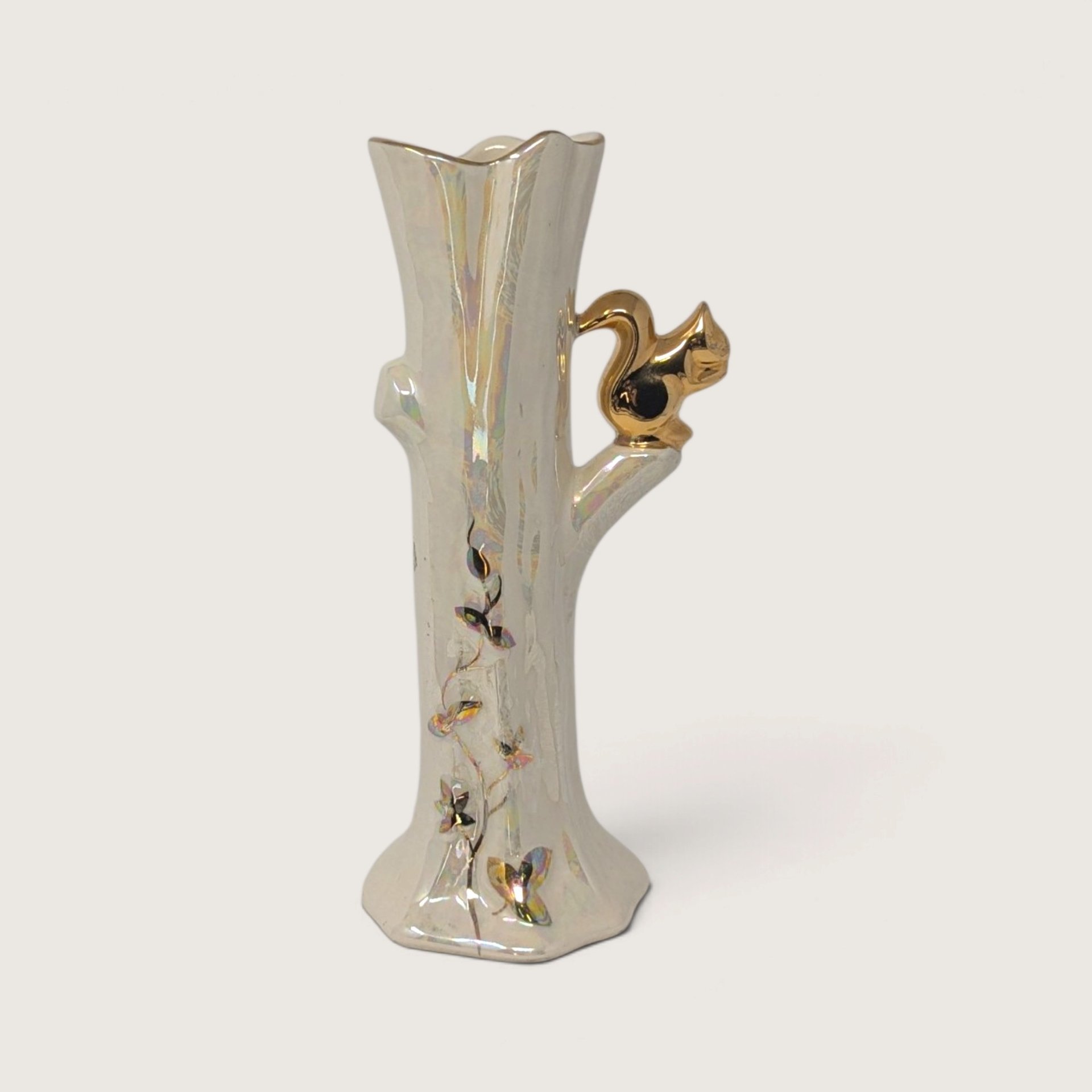 Vintage iridescent lusterware tree trunk bud vase with a shiny gold squirrel perched on a branch handle.   