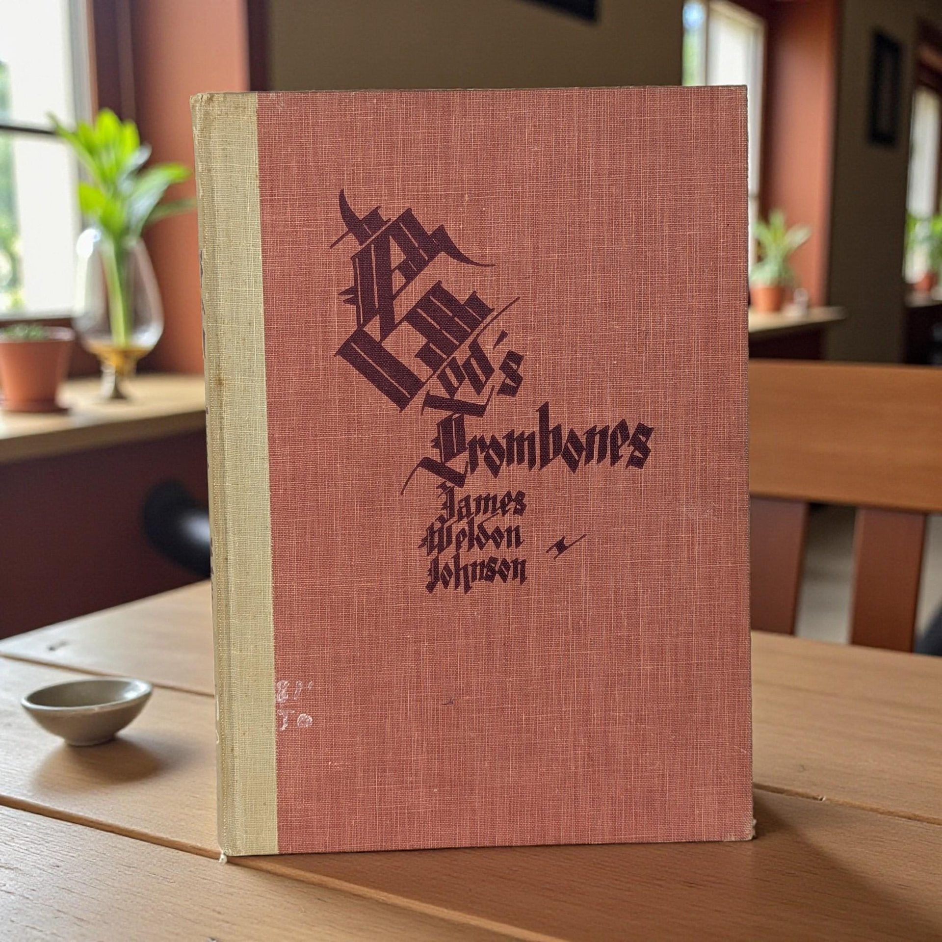 A dark hardcover book with a textured surface. The front cover features stylized black hand-lettered titles. The binding is sturdy, though the cover shows minor age-related markings, and the interior reveals powerful modernist silhouette illustrations in black and white.