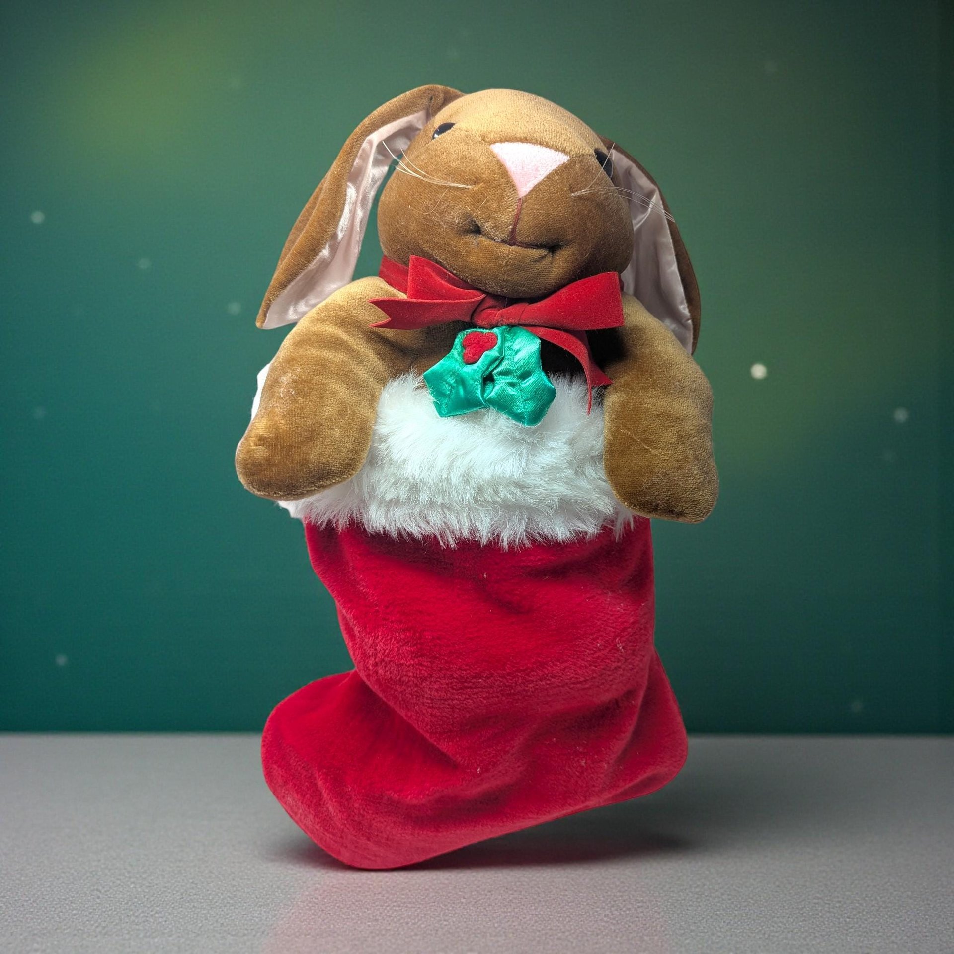 1985 Rabbit Ears Plush Rabbit in Stocking. Measures about 20" total length. The rabbit comes out of the stocking. Good condition. Rabbit has a slight pink hue on chest.