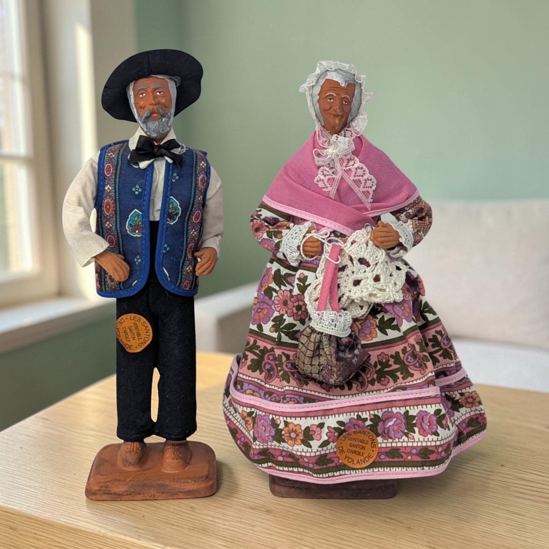 Vintage Santons Yolande France Clay Man and Woman Figures. They measure about 10 and 10.25" in height. There appears to be wire in the arms as they slightly move. Very good condition. They still have their stickers.