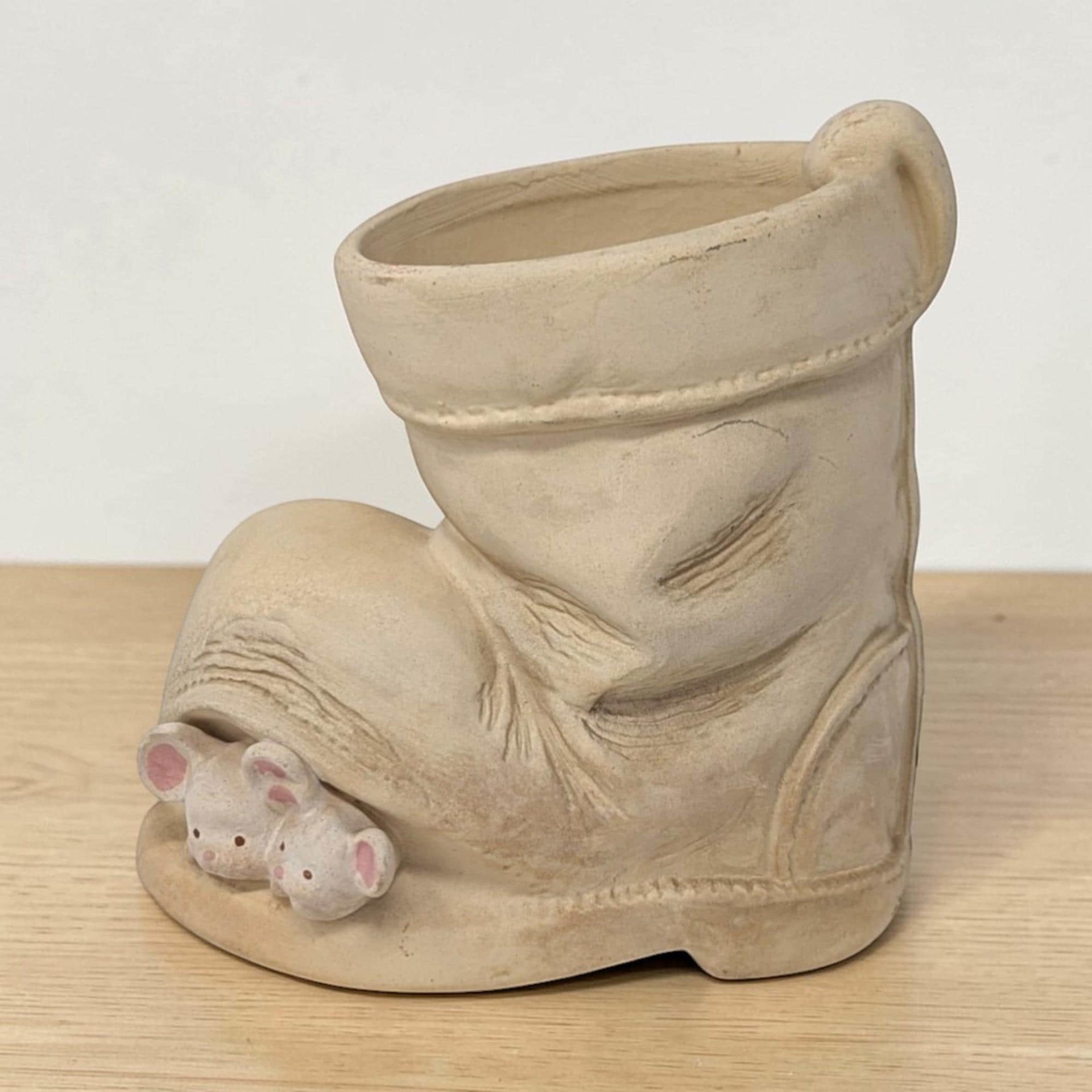 Small ceramic planter shaped like a weathered brown work boot. Two white mice with pink ears are perched on the toe and rim. Toffee-colored glaze with dark brown antiquing in the crevices and faux-stitching details.