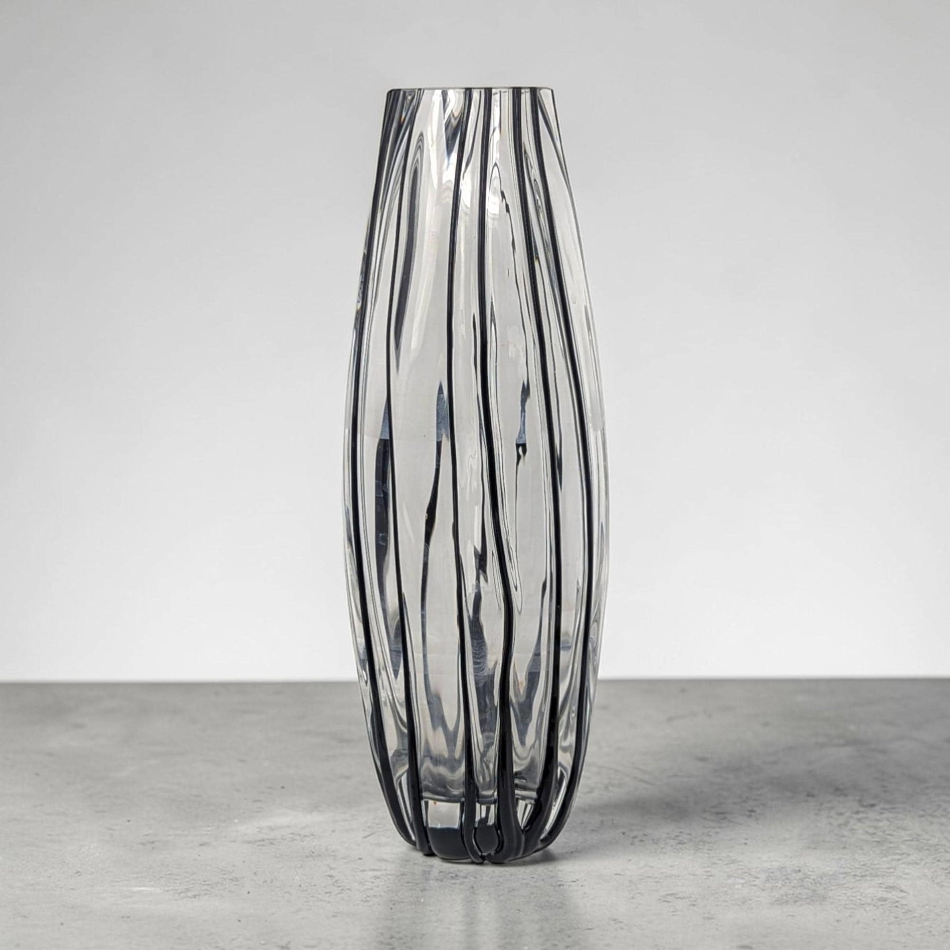 Tall, slender glass vase with a narrow 2-inch opening. The body features alternating vertical stripes of opaque white and clear glass. The silhouette tapers toward a flared rim and sits on a sturdy, clear glass base.