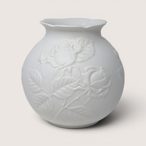 Vintage Kaiser white bisque porcelain vase featuring an embossed rose and foliage relief design.