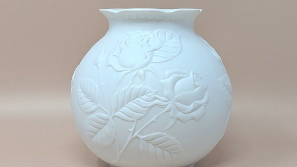 Kaiser West Germany white bisque porcelain vase with a globular body and flared rim. Features a high-relief embossed rose and leaf design with a soft matte finish. 5.5 inches tall.