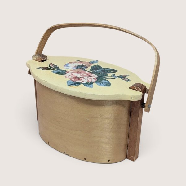 Vintage wooden lidded Basketville swing handle basket with a pale yellow painted floral top.