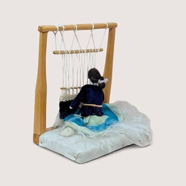 Vintage Native American handmade weaver figurine with a miniature wooden loom and textile display.