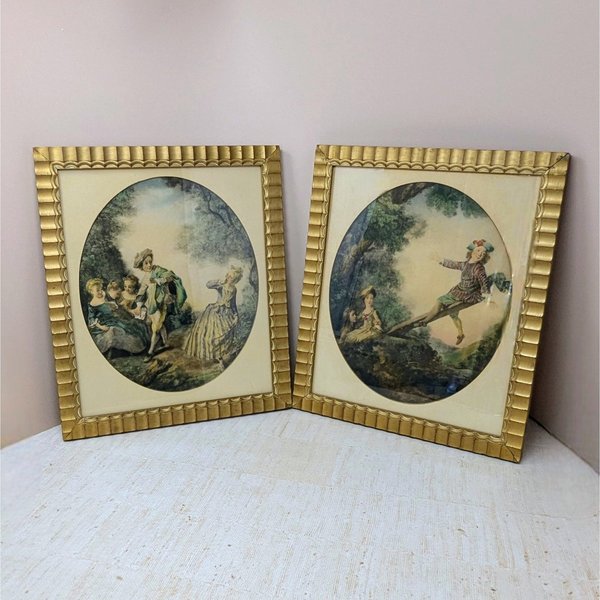Set of two 1940s framed art prints by Nicolas Lancret titled "The Seesaw" and "Dropping the Handkerchief." Features pastoral Rococo scenes in ornate scalloped gold frames. 14.25 x 12.25 inches.
