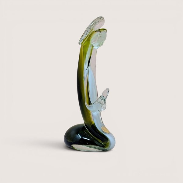 A vertical art glass sculpture of a person in a prayerful pose. A vibrant green inner layer is visible through the thick clear glass exterior, which curves into a stable, weighted base.