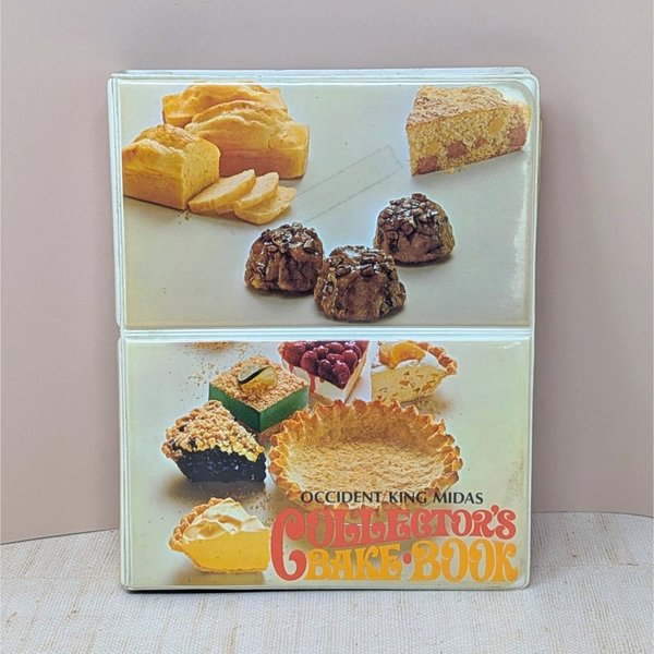 A vertical cookbook titled "Occident King Midas Collector's Bake Book." The cover features two panels of 1970s food photography showing pies, cakes, and breads. Orange and yellow "bubble" style typography.
